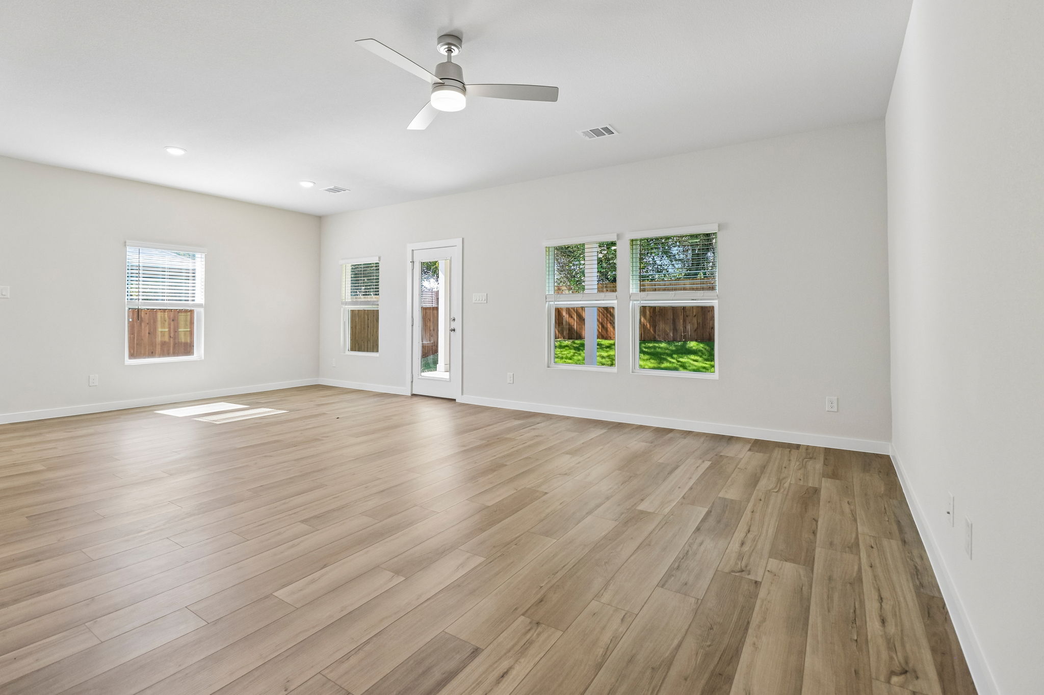 A room with a wood floor and a ceiling fan.