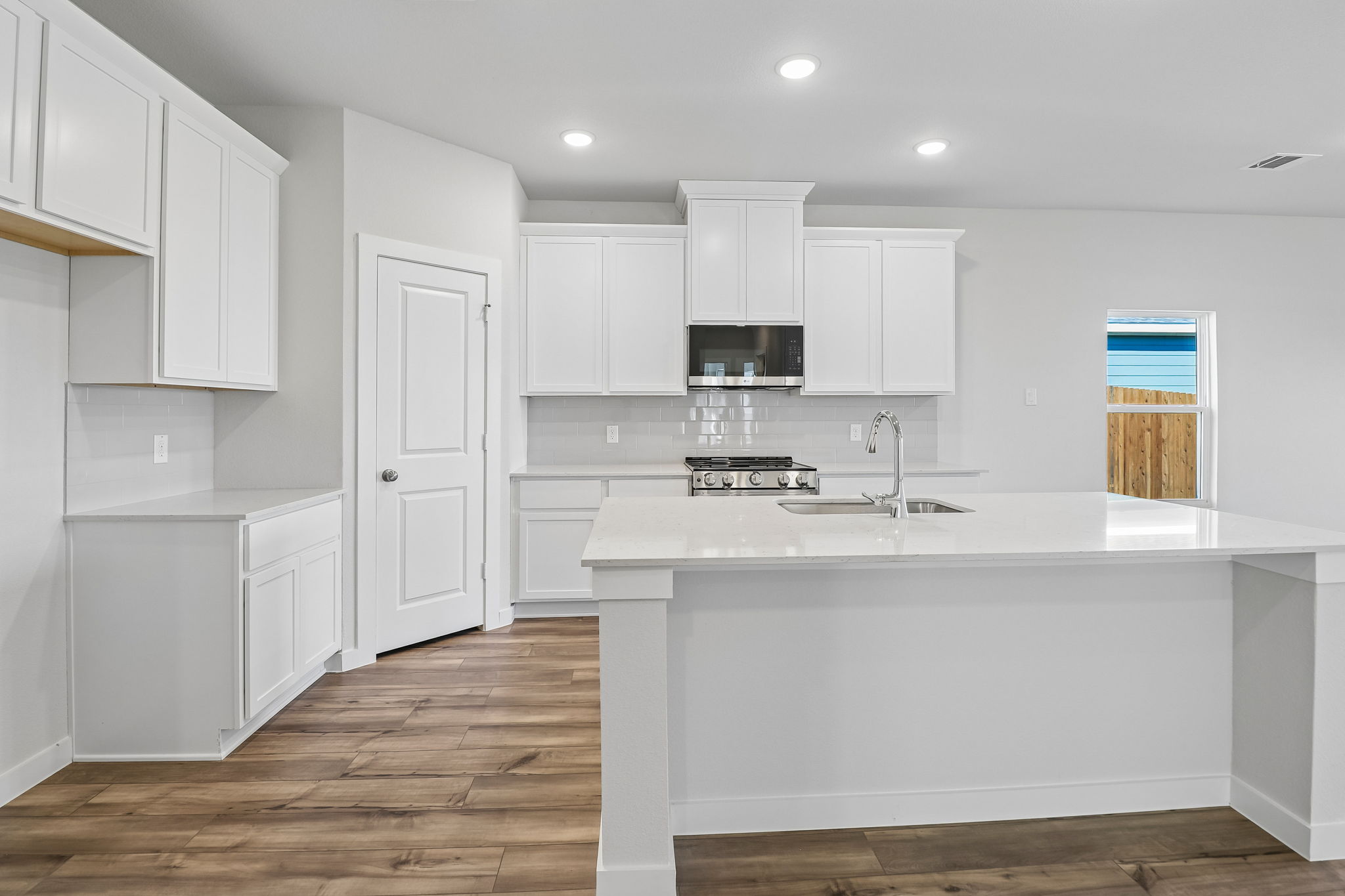 A kitchen with white cabinets.