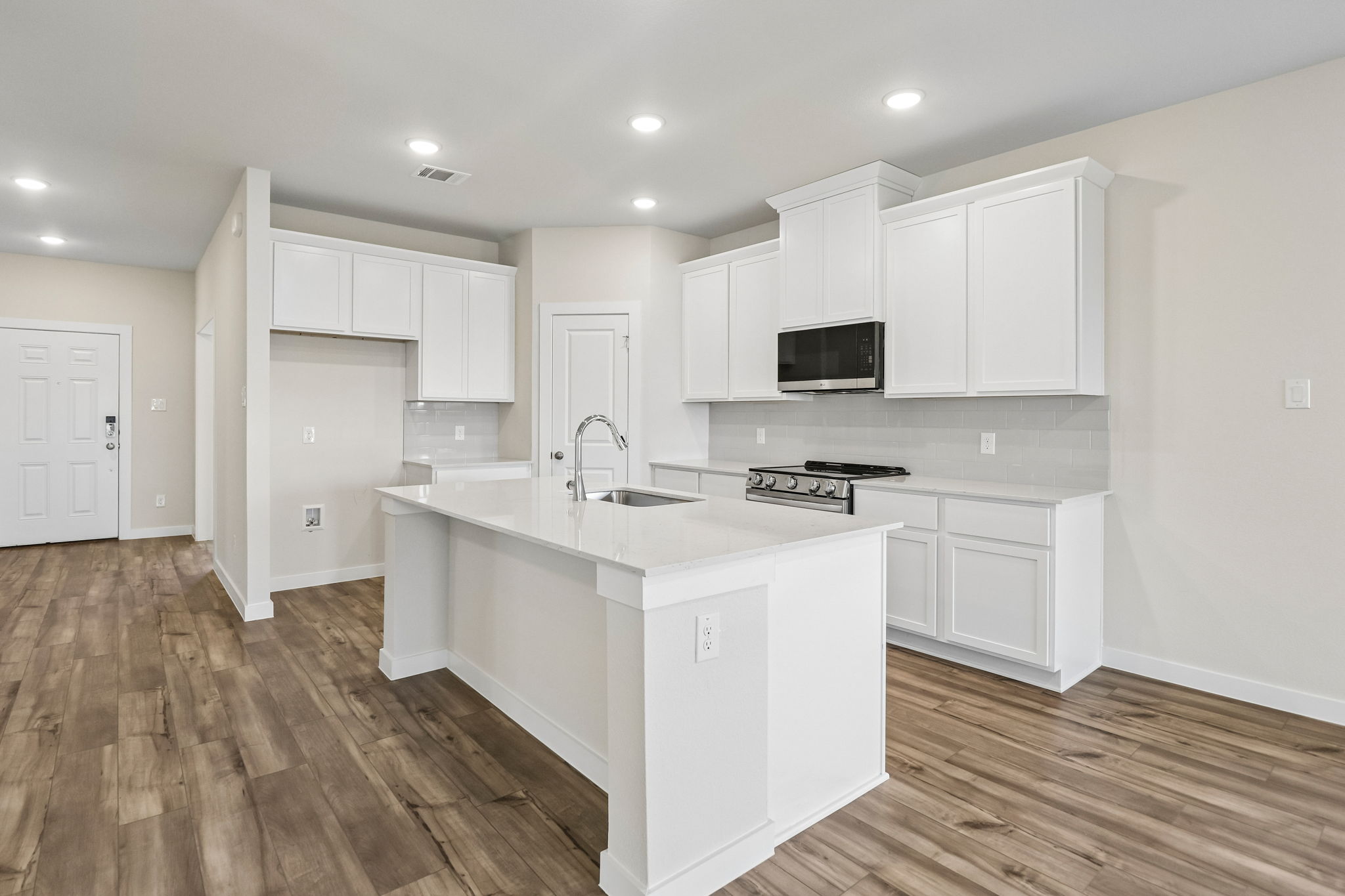 A kitchen with white cabinets.