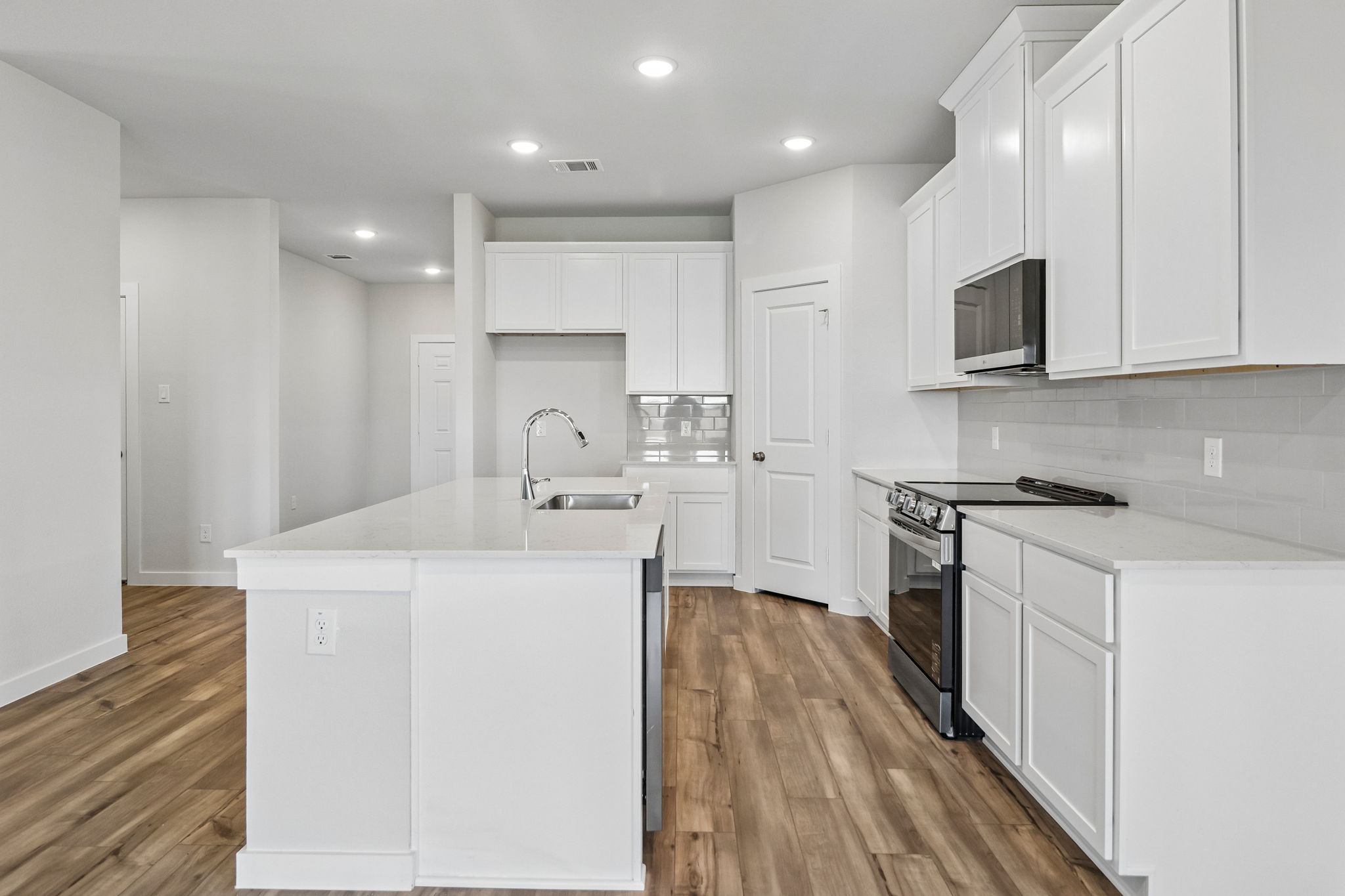 A kitchen with white cabinets.