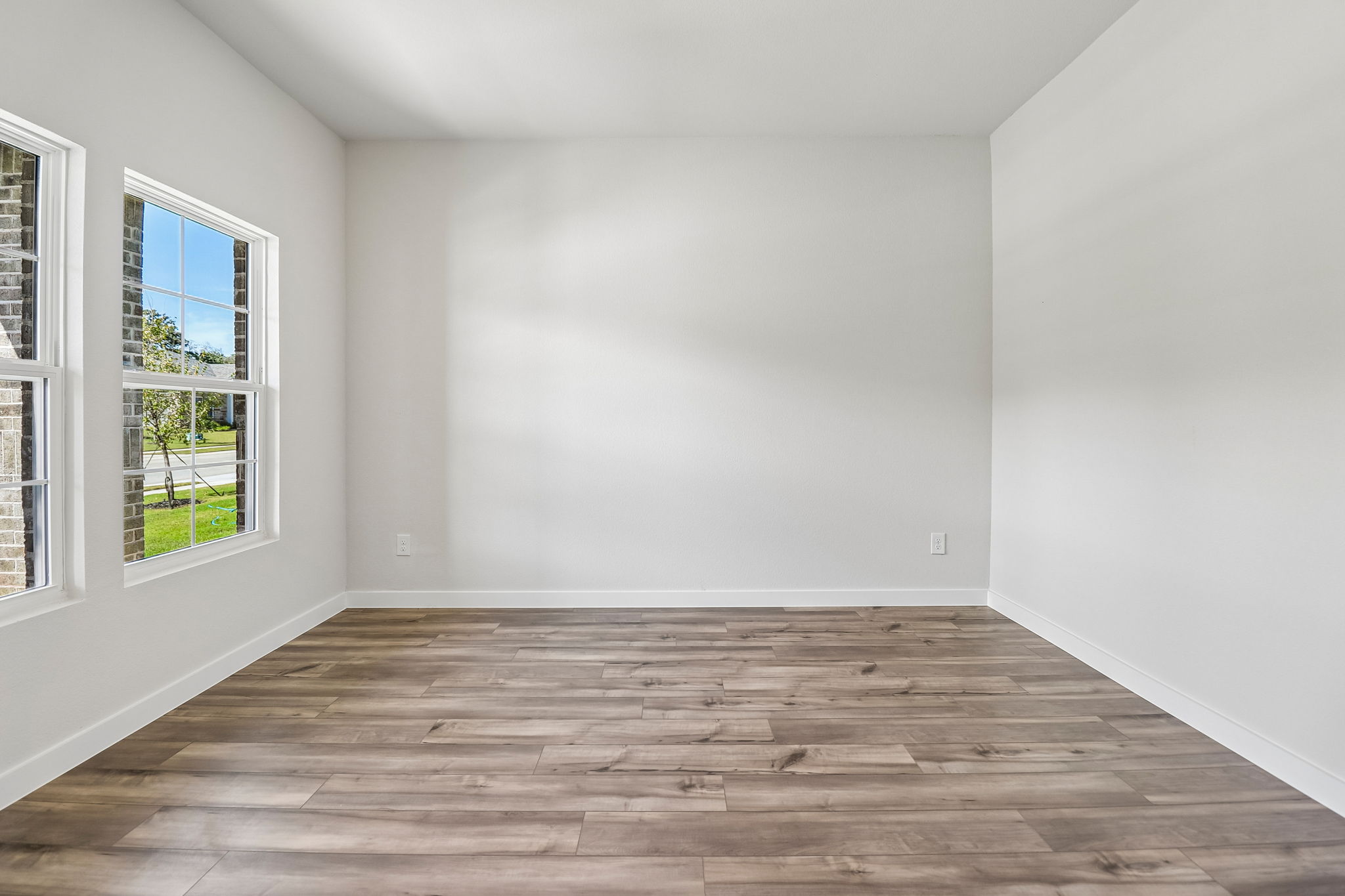 A room with a wood floor and windows.