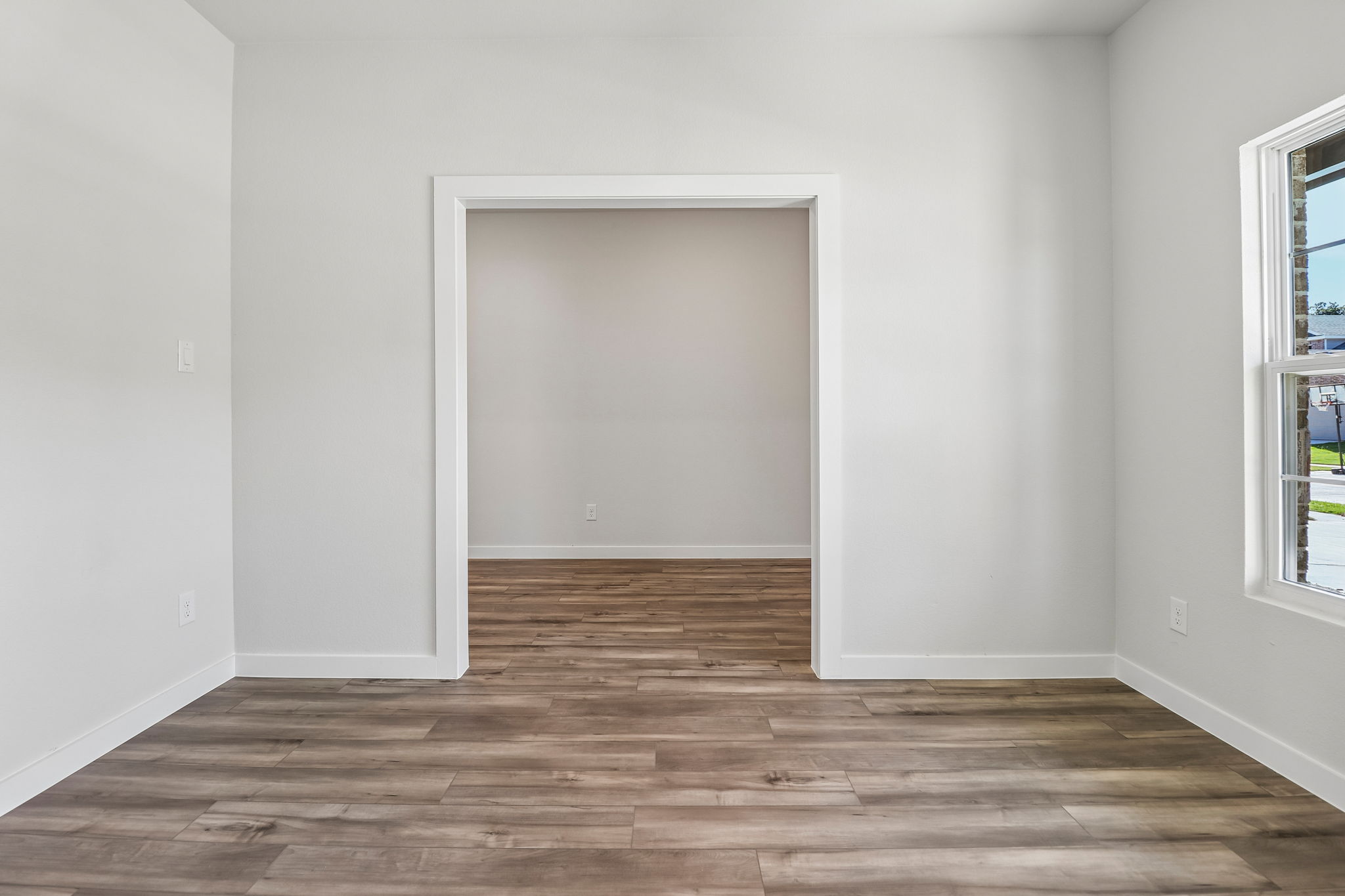 A room with a wood floor and a white door.