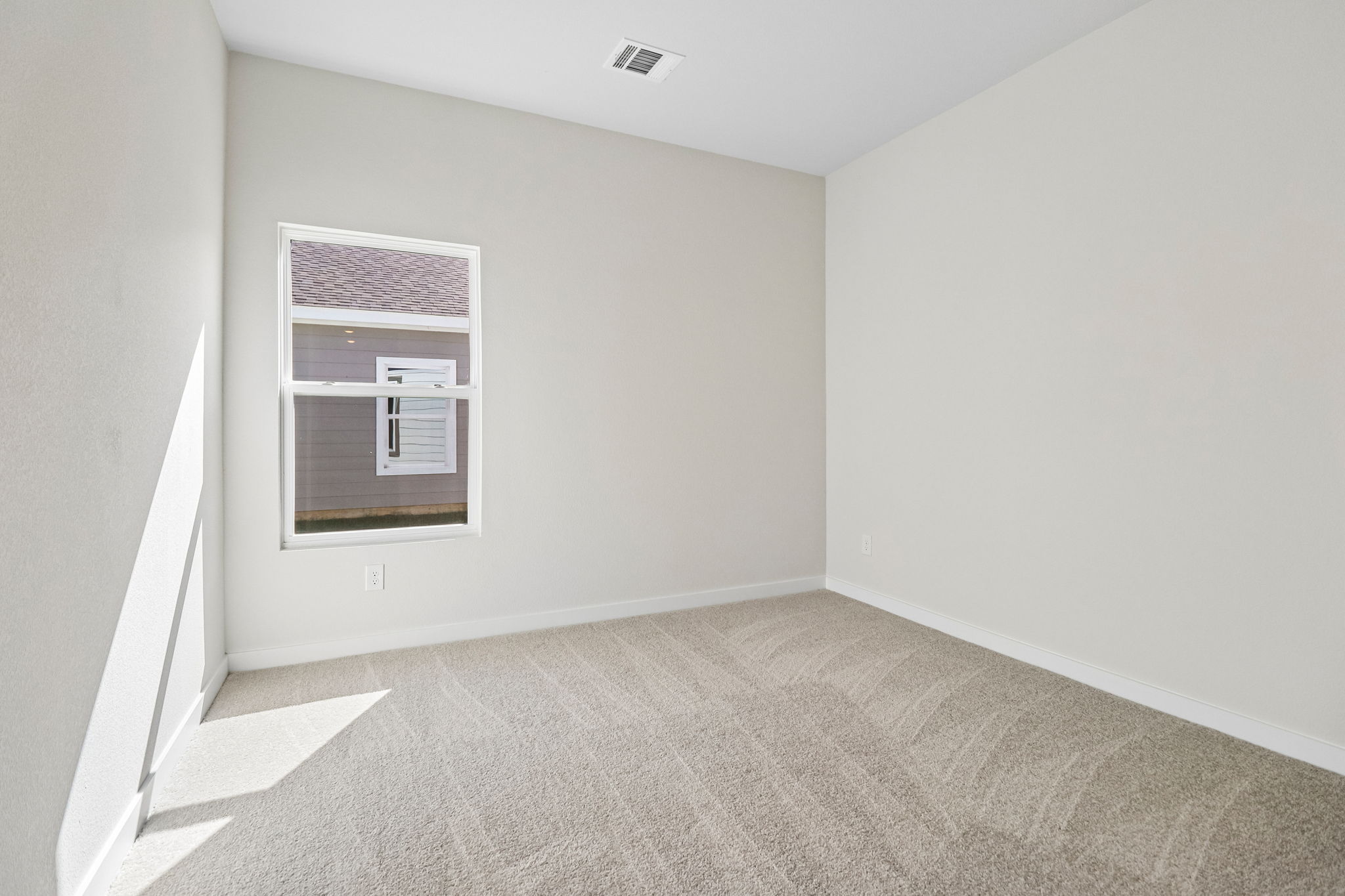 A room with a carpet and a window.