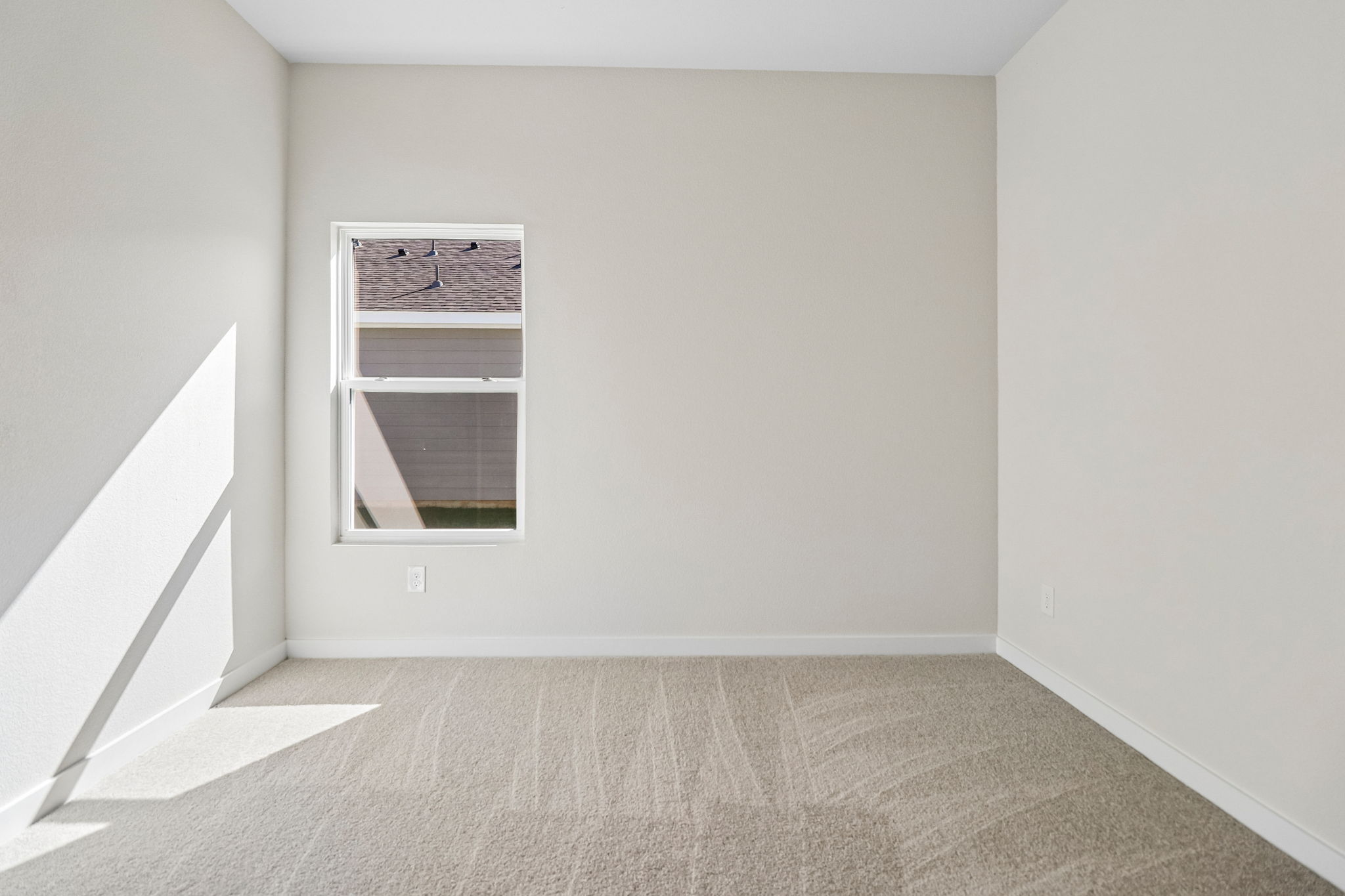 A room with a window and a rug.