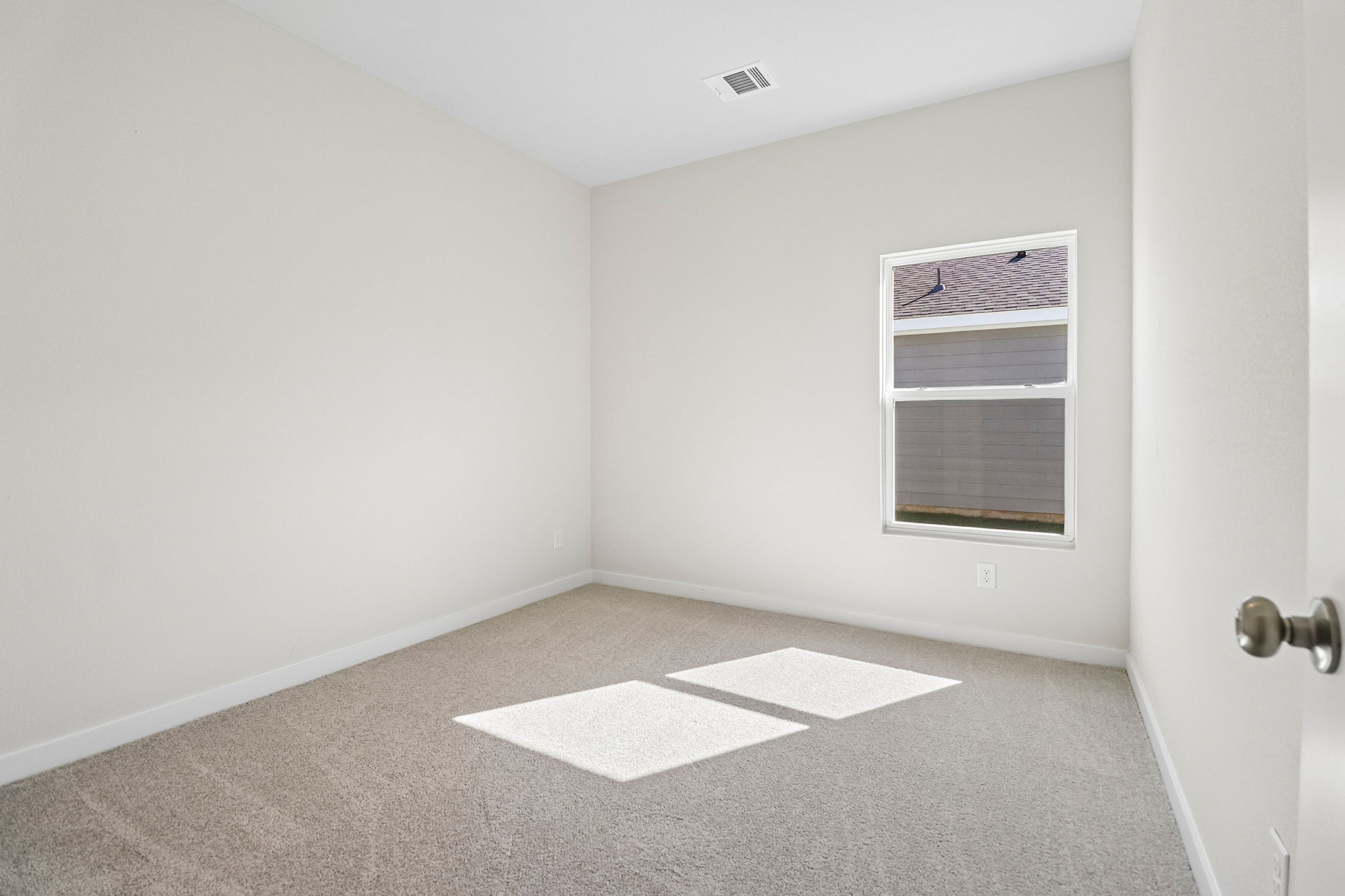 A room with a rug and a window.