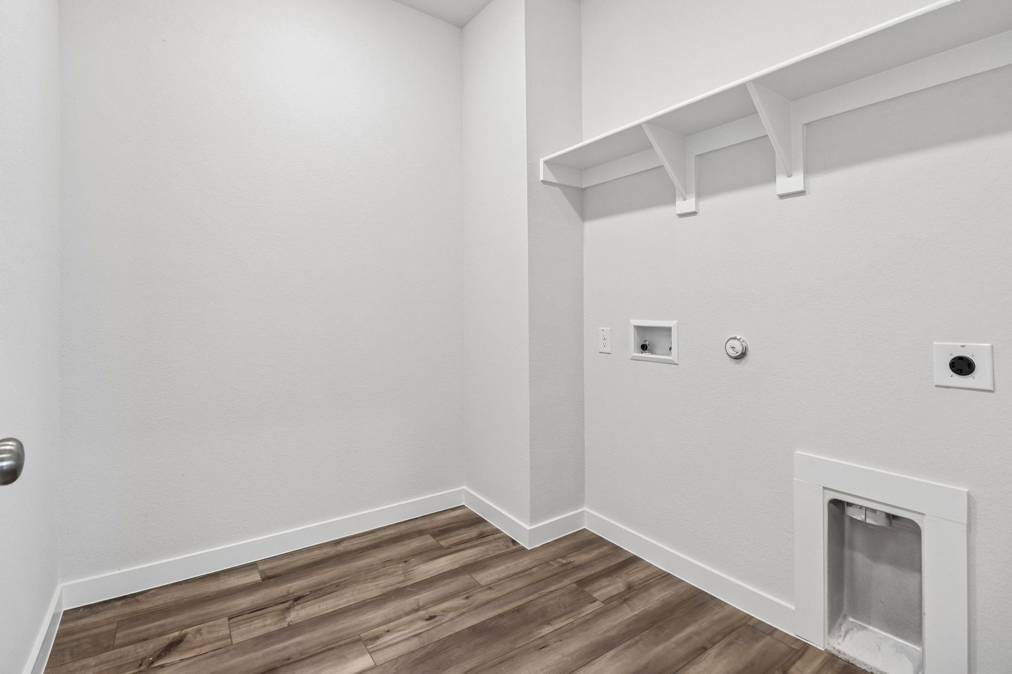 A room with a wood floor and white walls.