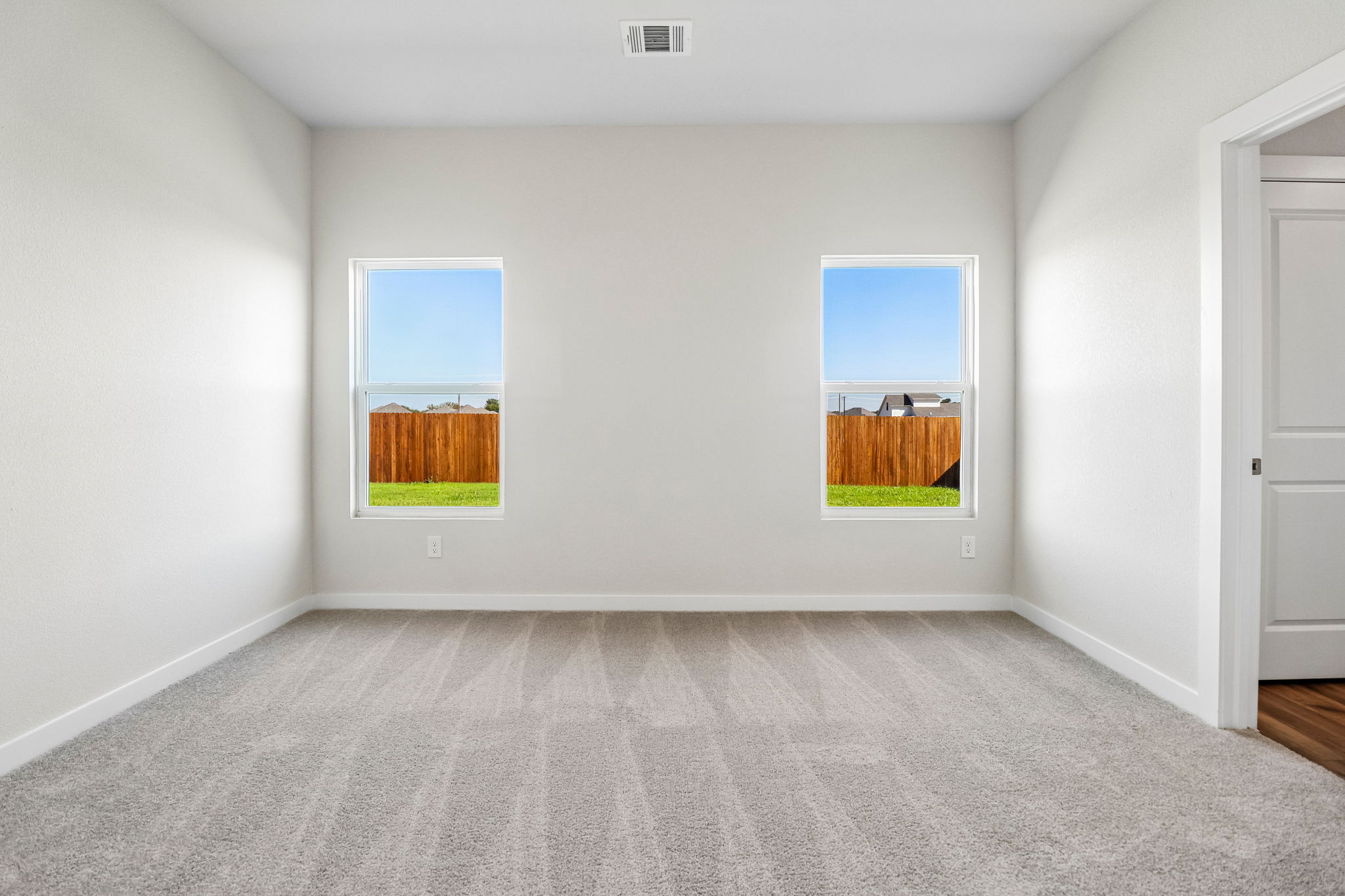 A room with a window and a rug.