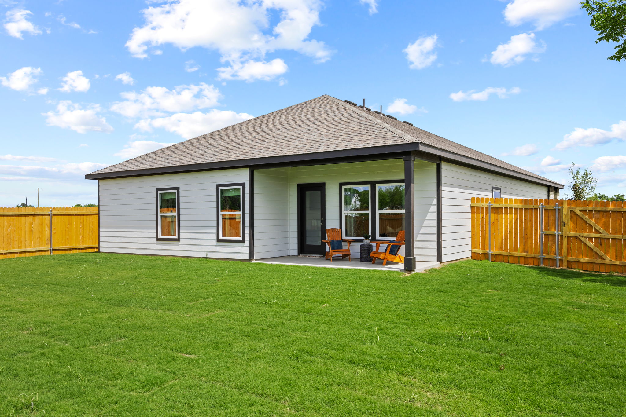 A house with a fence and lawn.