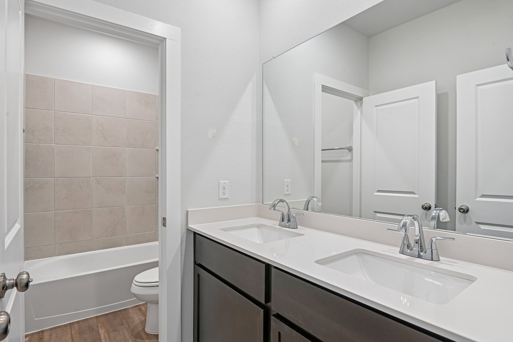 A bathroom with a sink toilet and mirror.