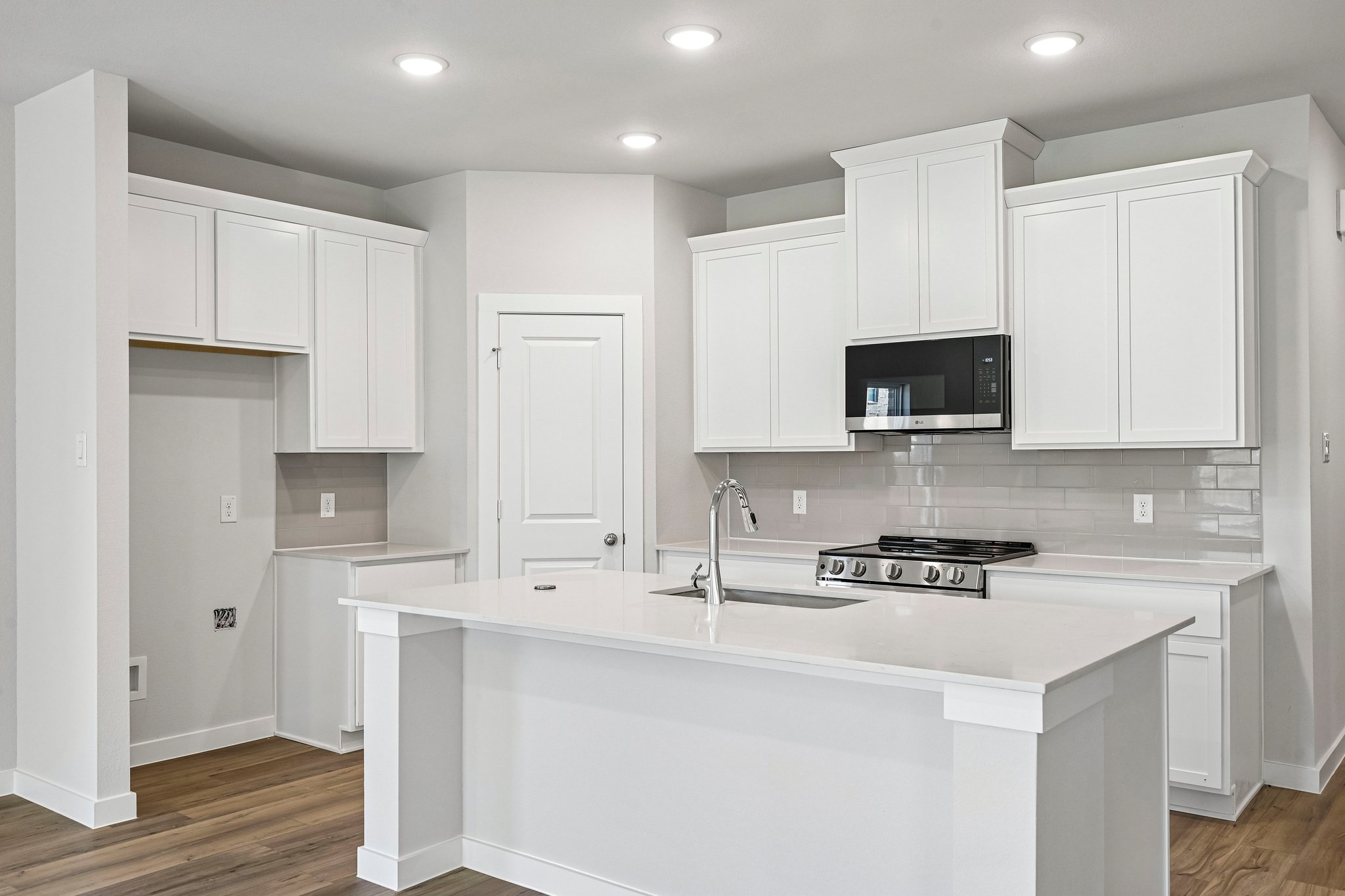 A kitchen with white cabinets.