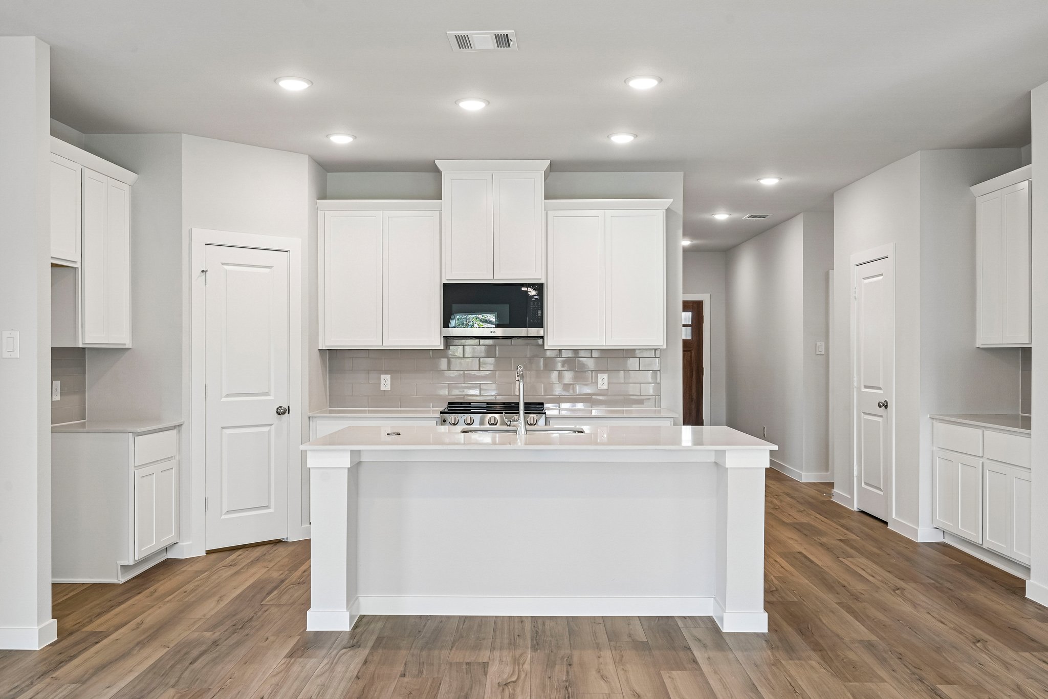 A kitchen with white cabinets.
