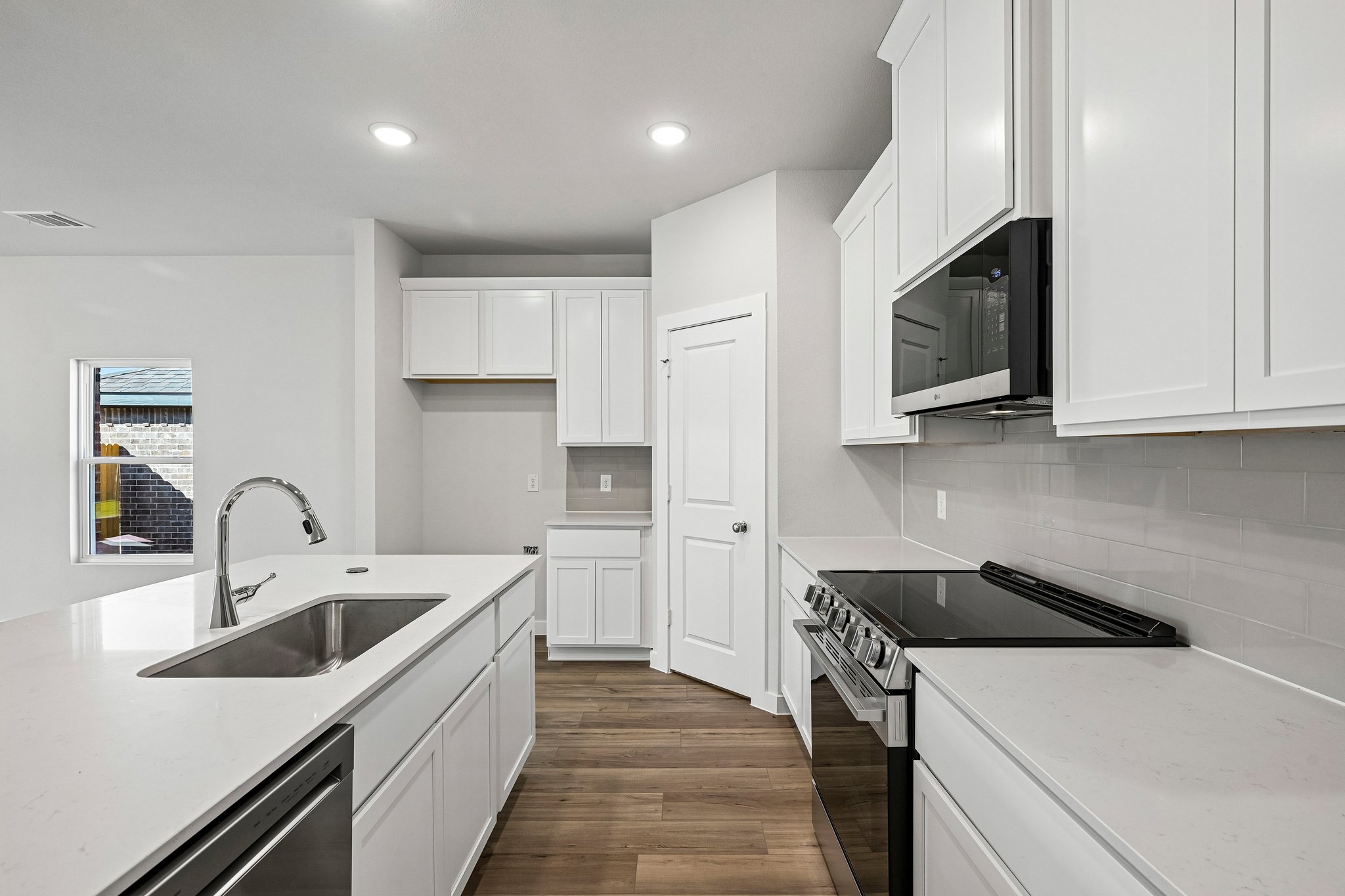 A kitchen with white cabinets.