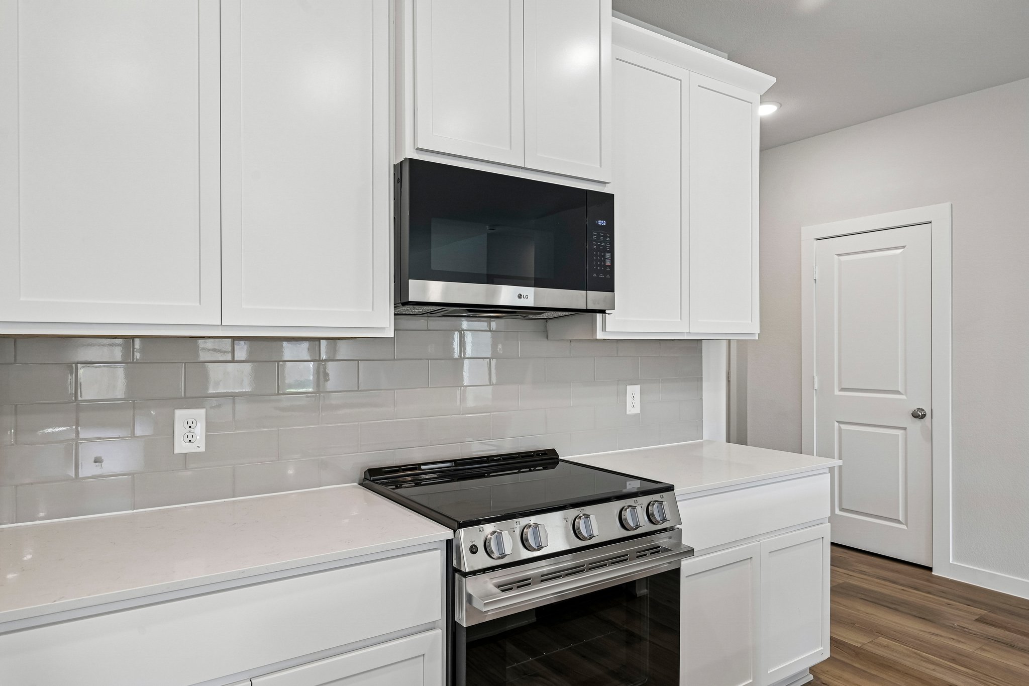 A kitchen with white cabinets.