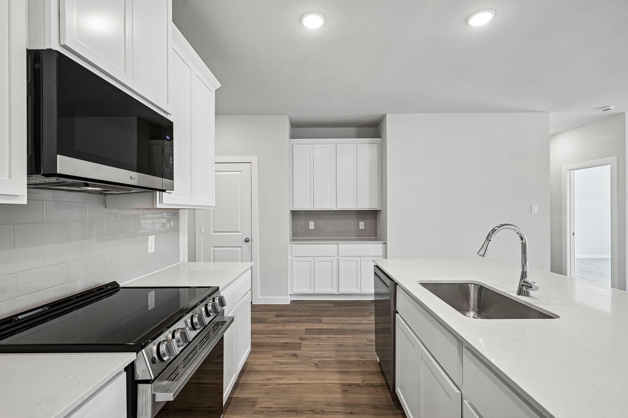 A kitchen with white cabinets.
