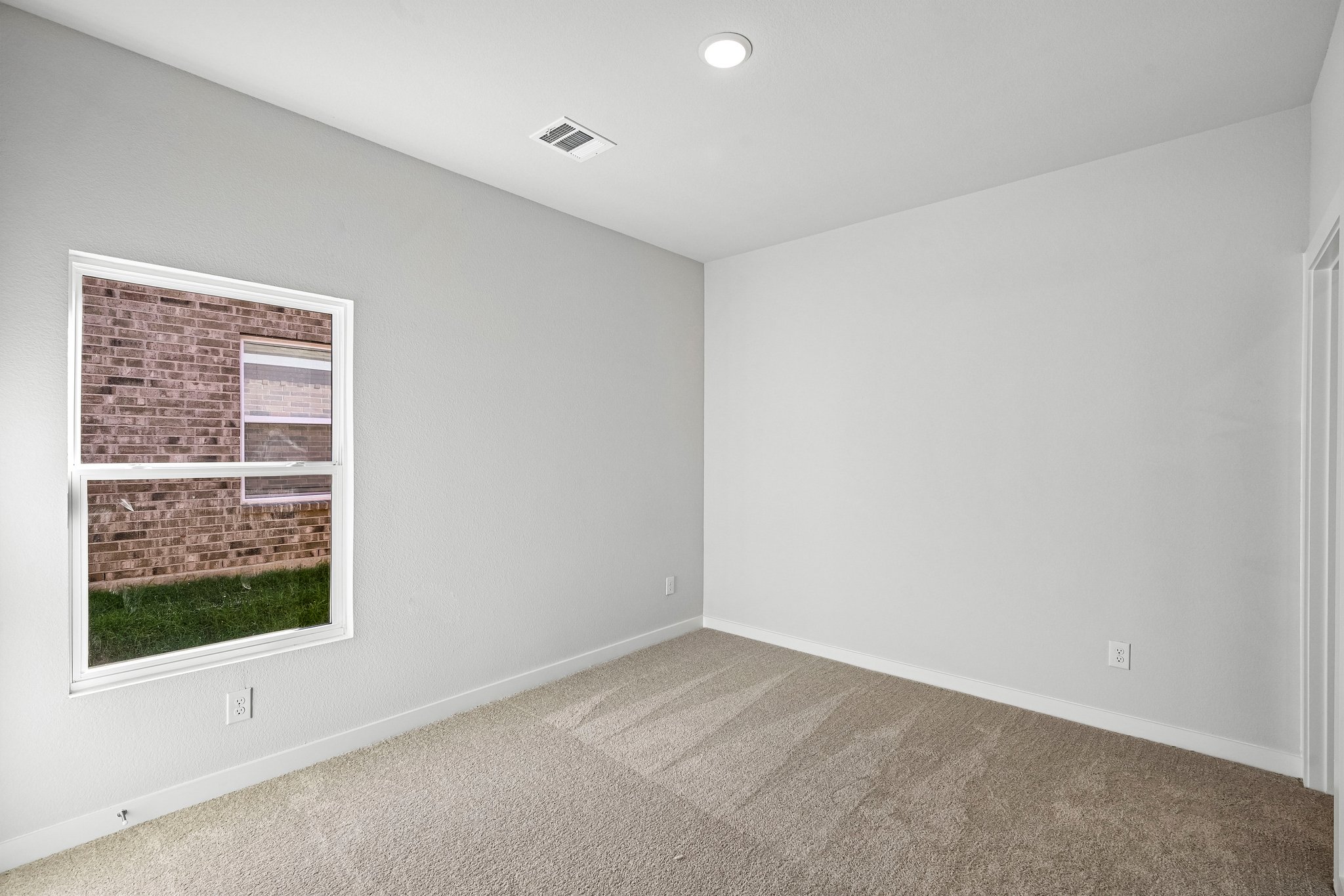 A room with a window and a carpet.