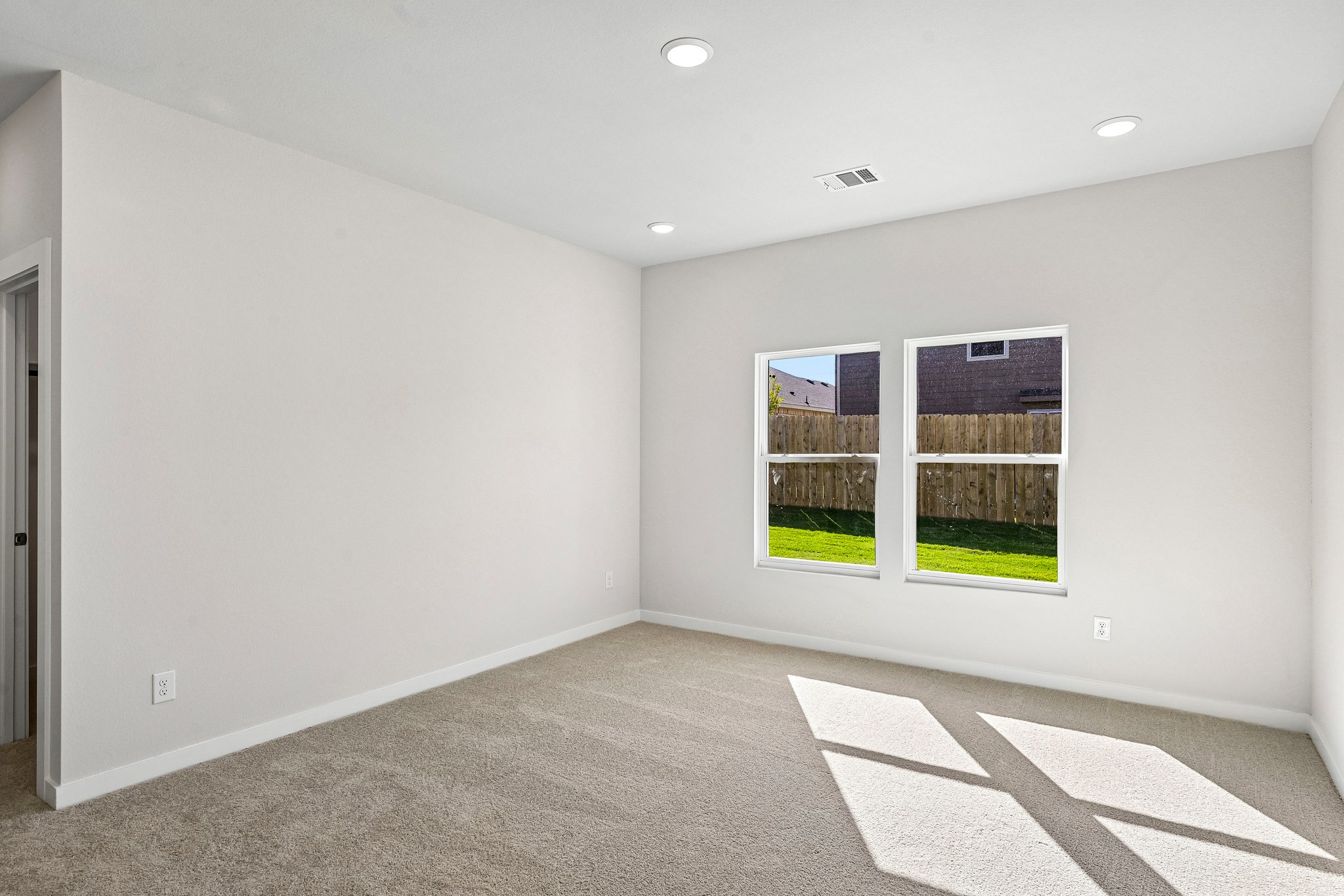 A room with a window and a rug.