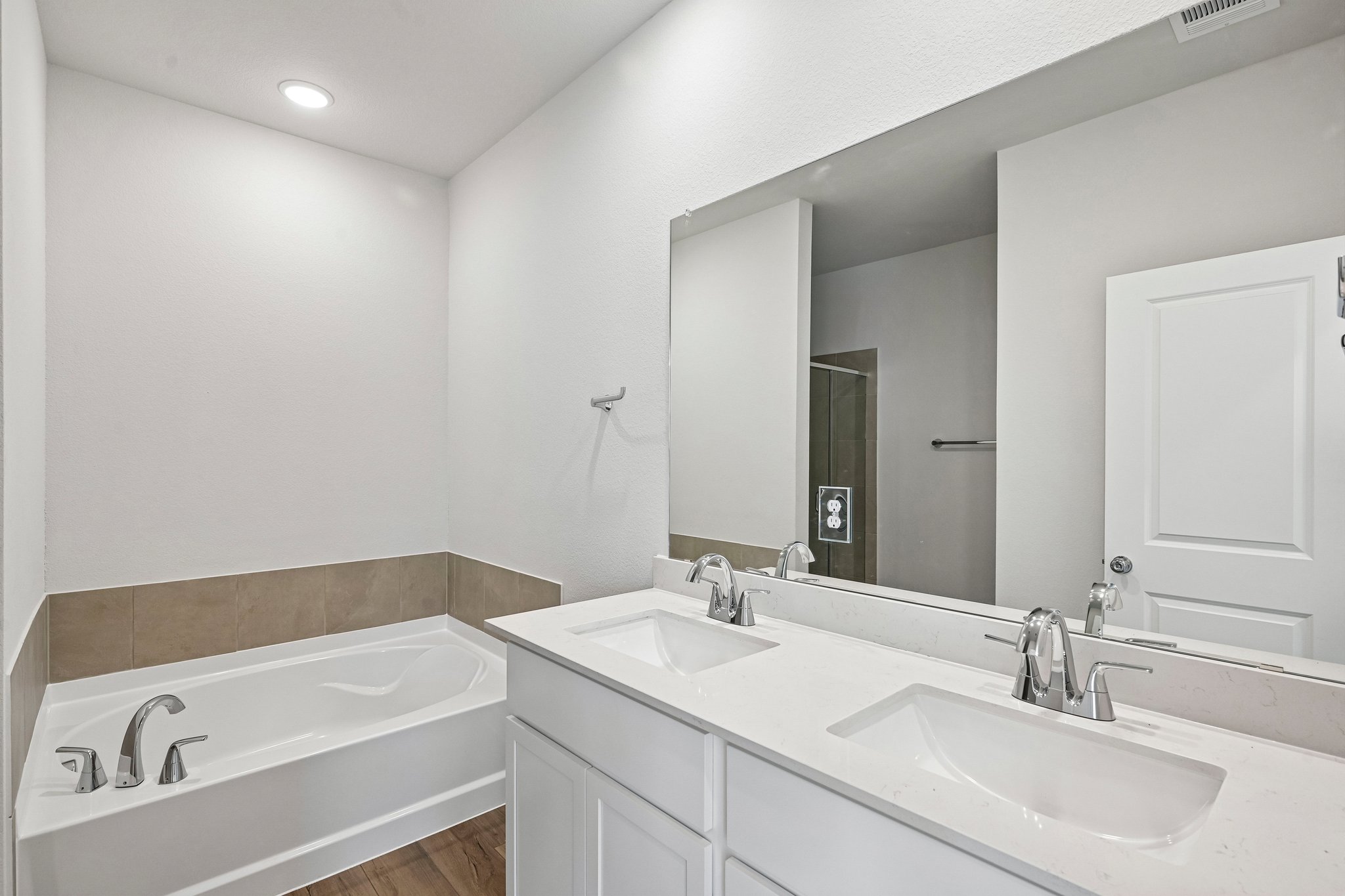 A bathroom with a tub sink and mirrors.