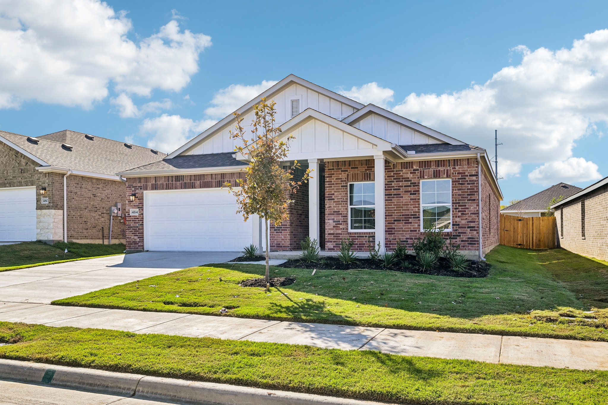 A brick house with a tree in the front.