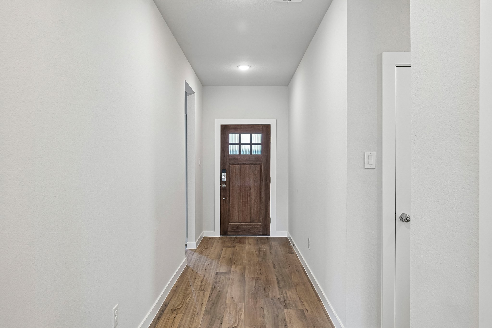 A hallway with a wood floor.
