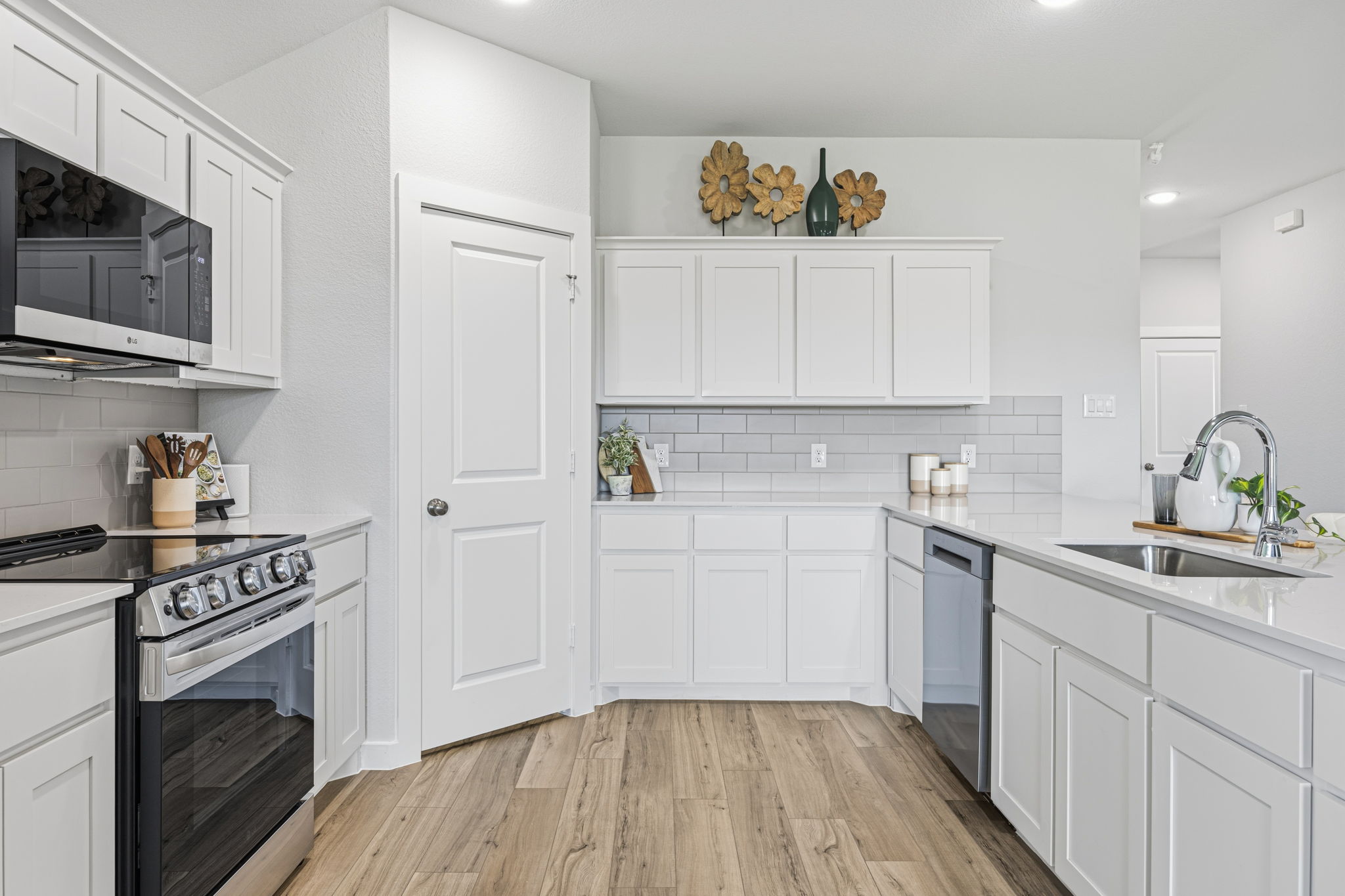 A kitchen with white cabinets.