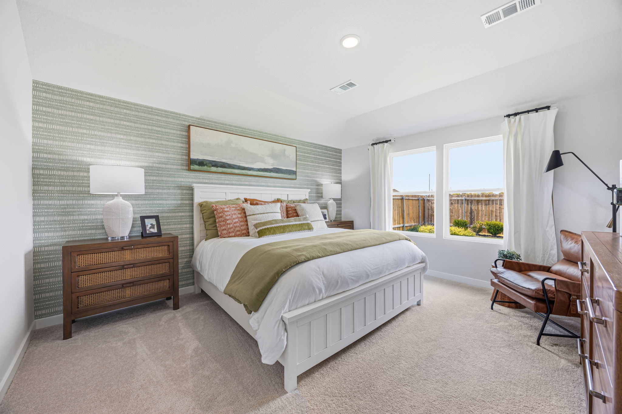 A bedroom with a bed and a chair.