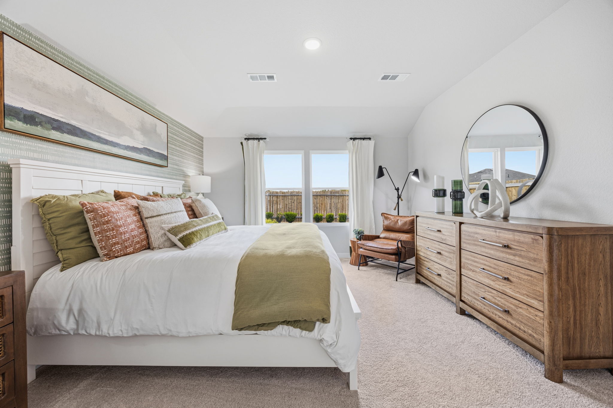 A bedroom with a large mirror.