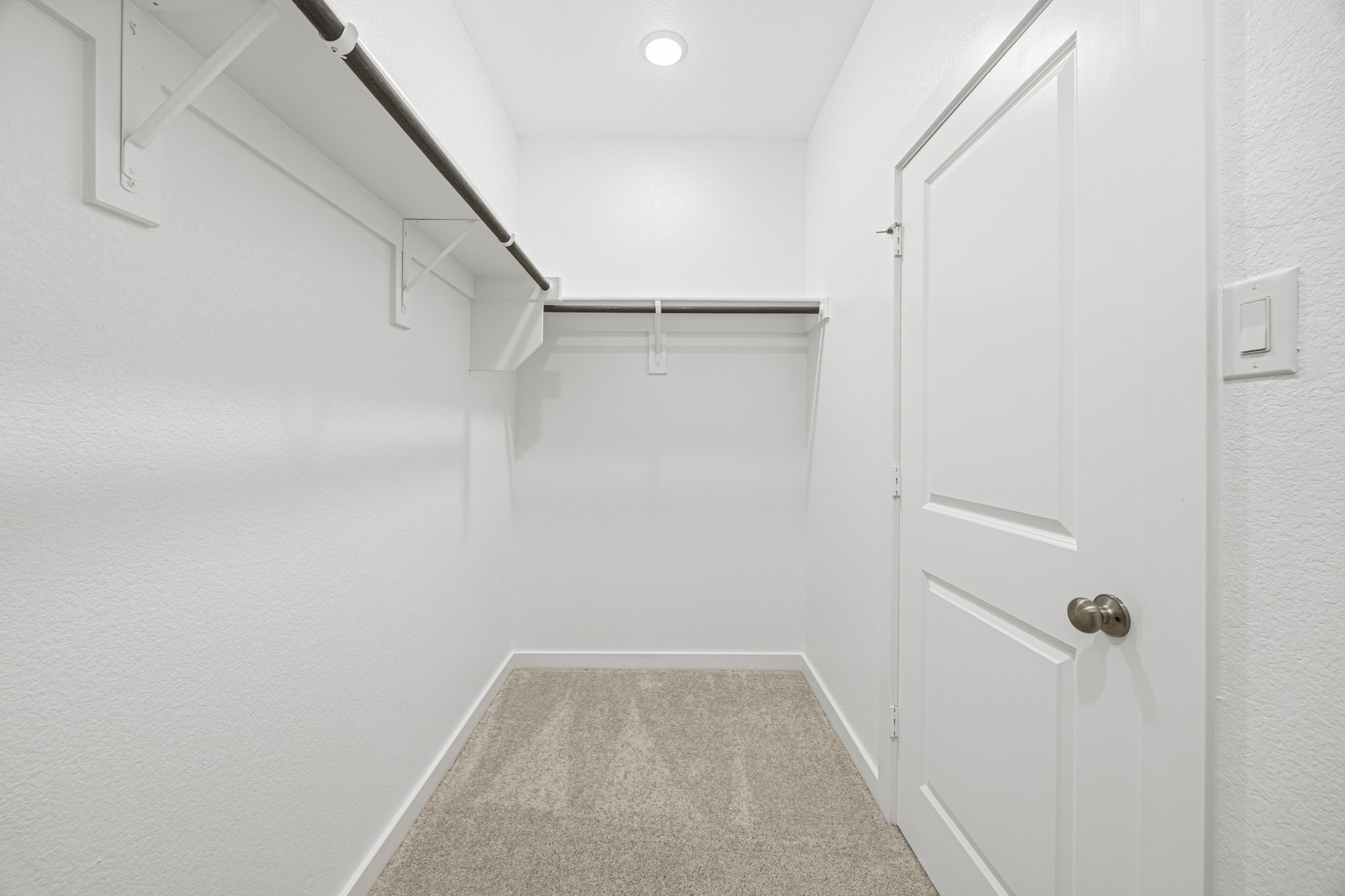 A white hallway with a rug.