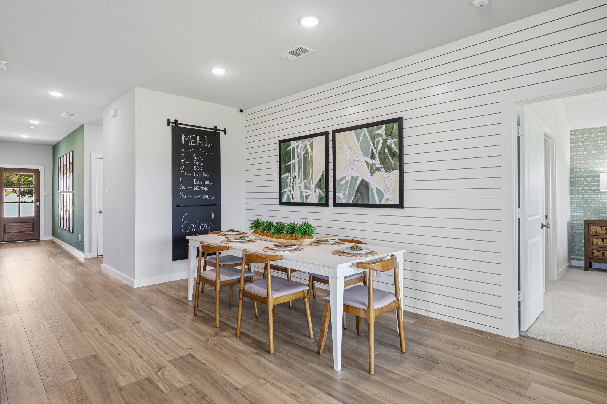 A dining room with a table and chairs.