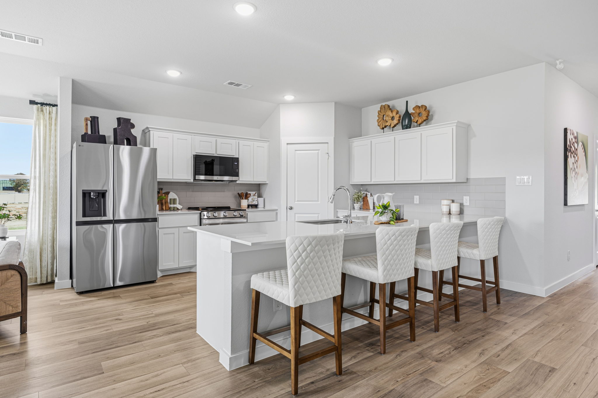 A kitchen with white cabinets.