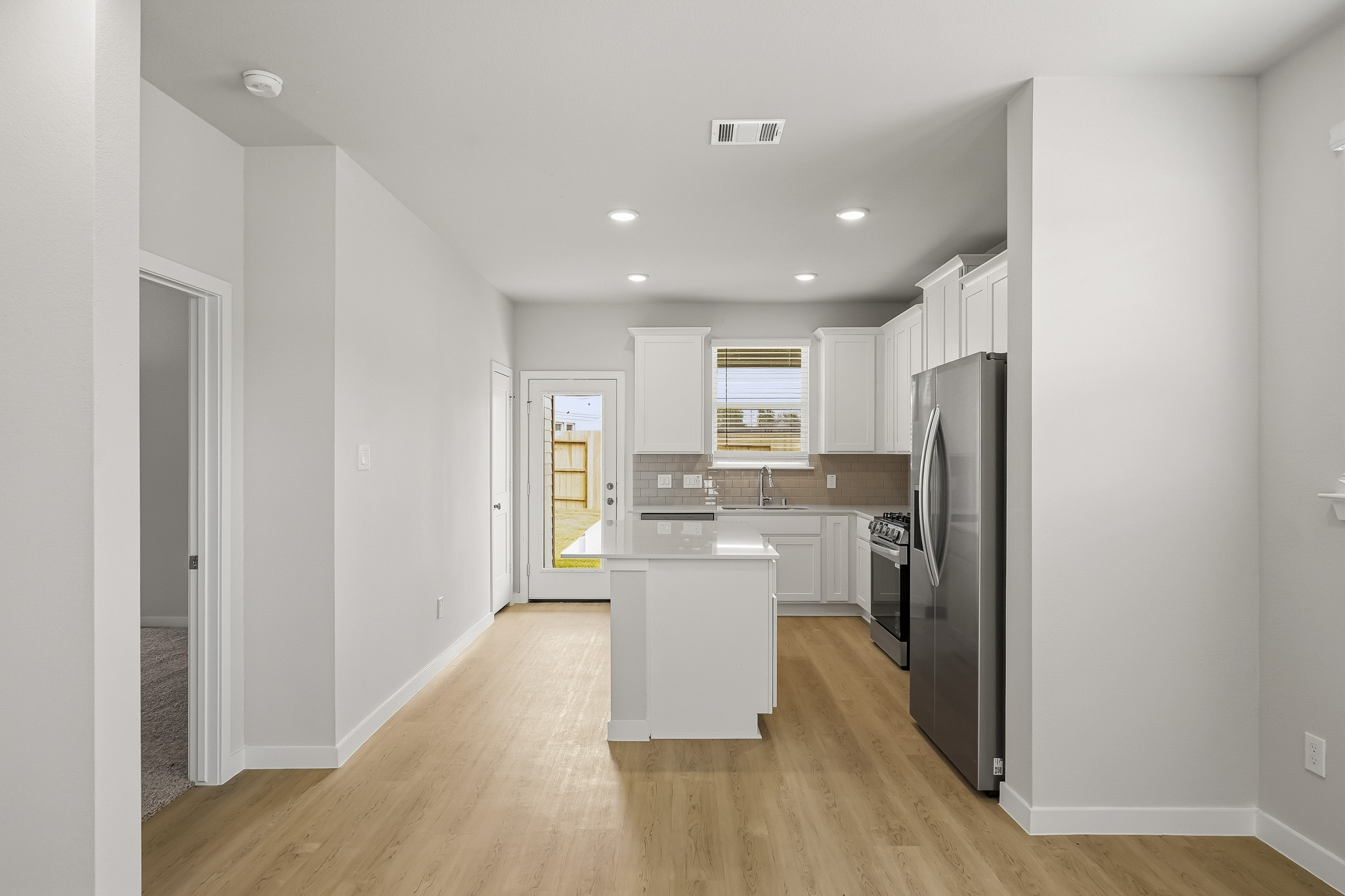 A kitchen with white cabinets.