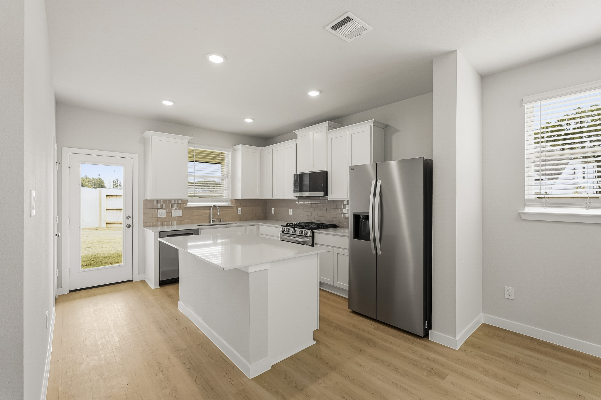 A kitchen with white cabinets.