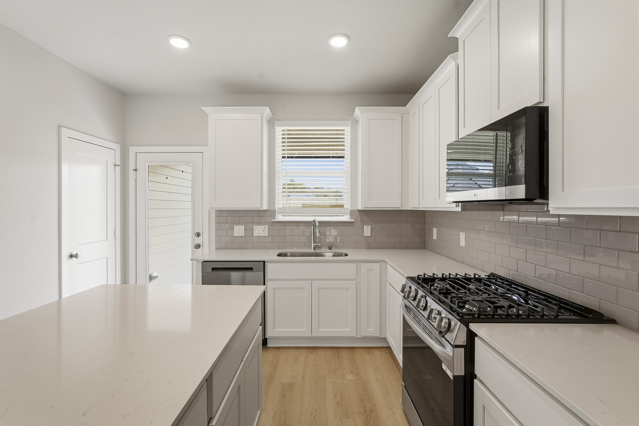 A kitchen with white cabinets.