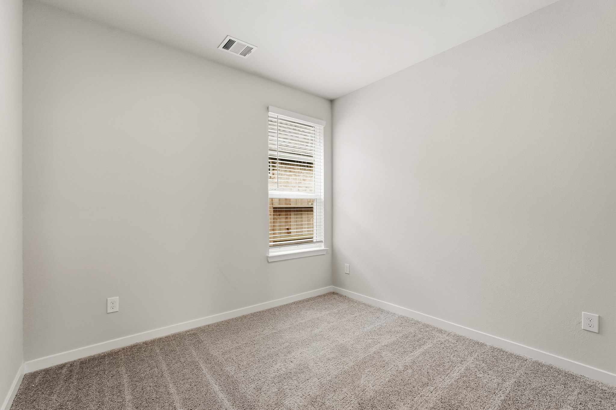 A room with a window and carpet.