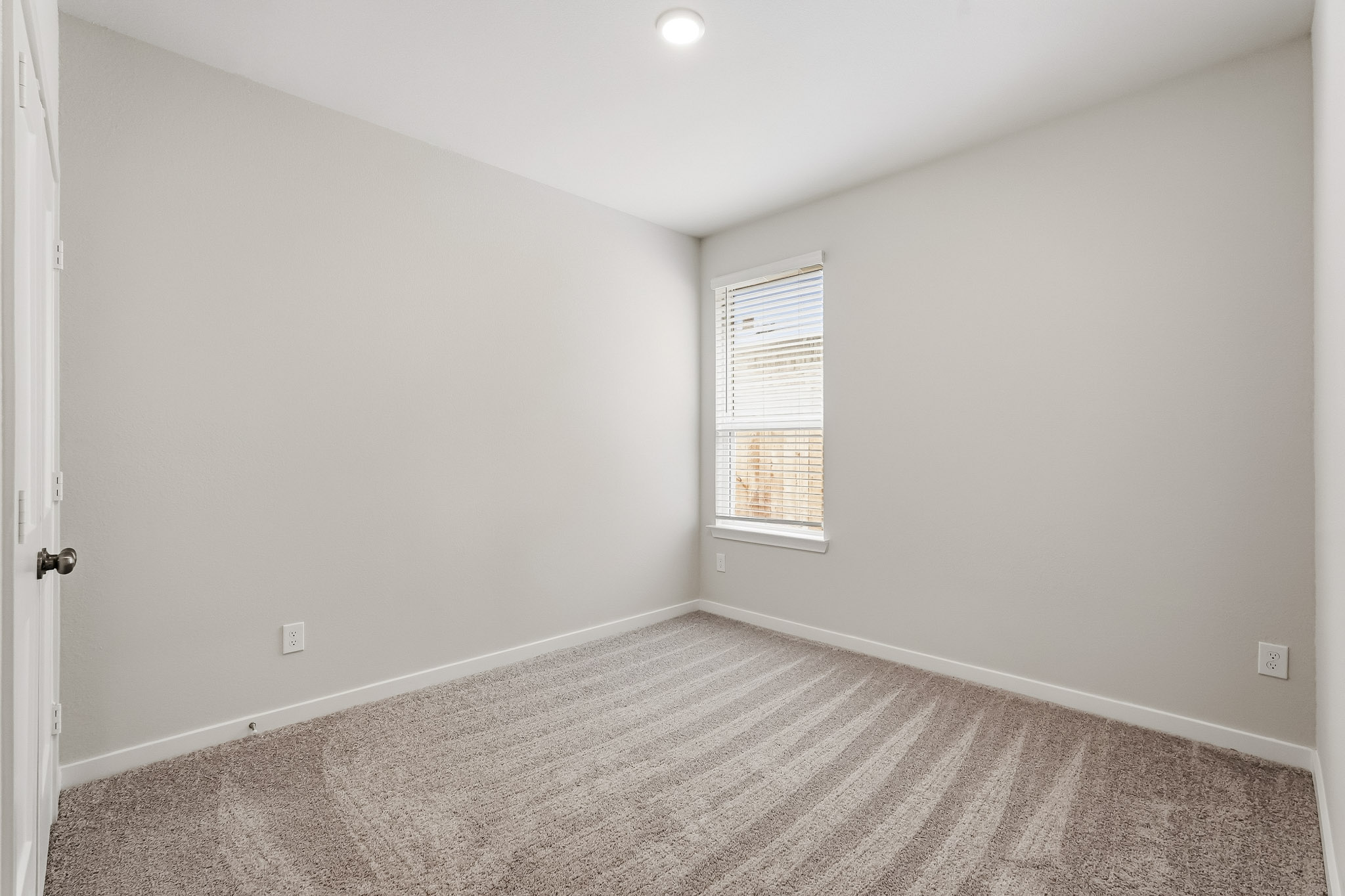 A room with a carpet and a window.