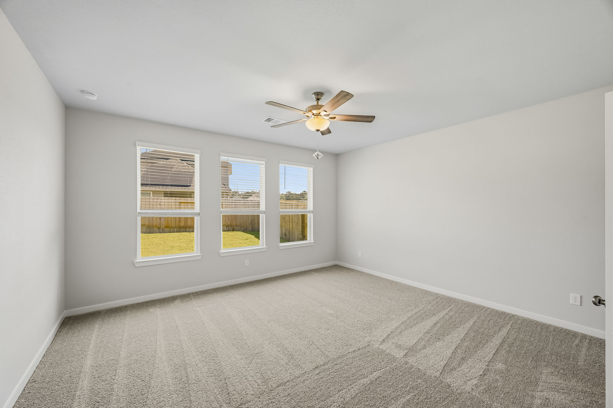 A room with a ceiling fan and a window.