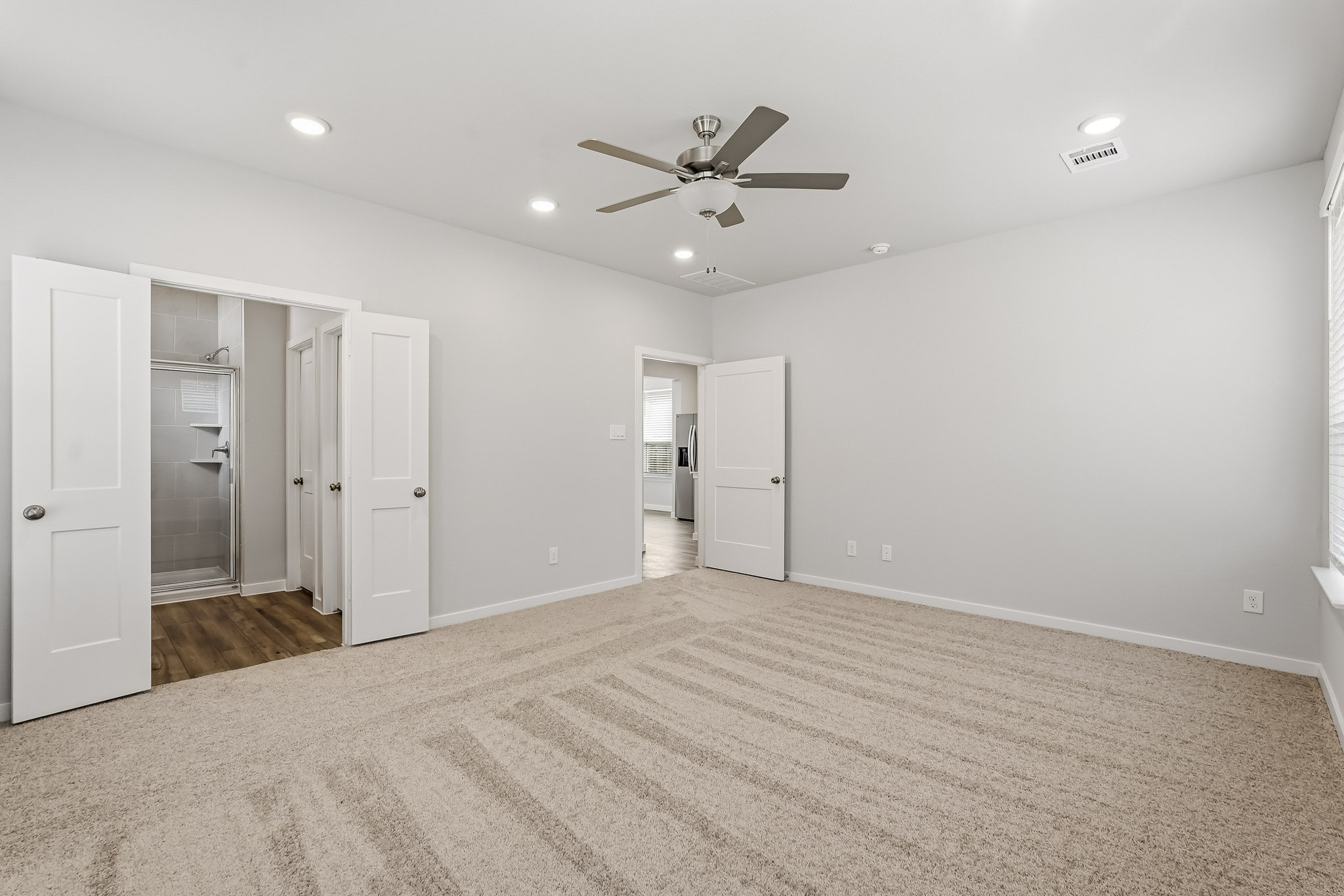 A room with white walls and a ceiling fan.