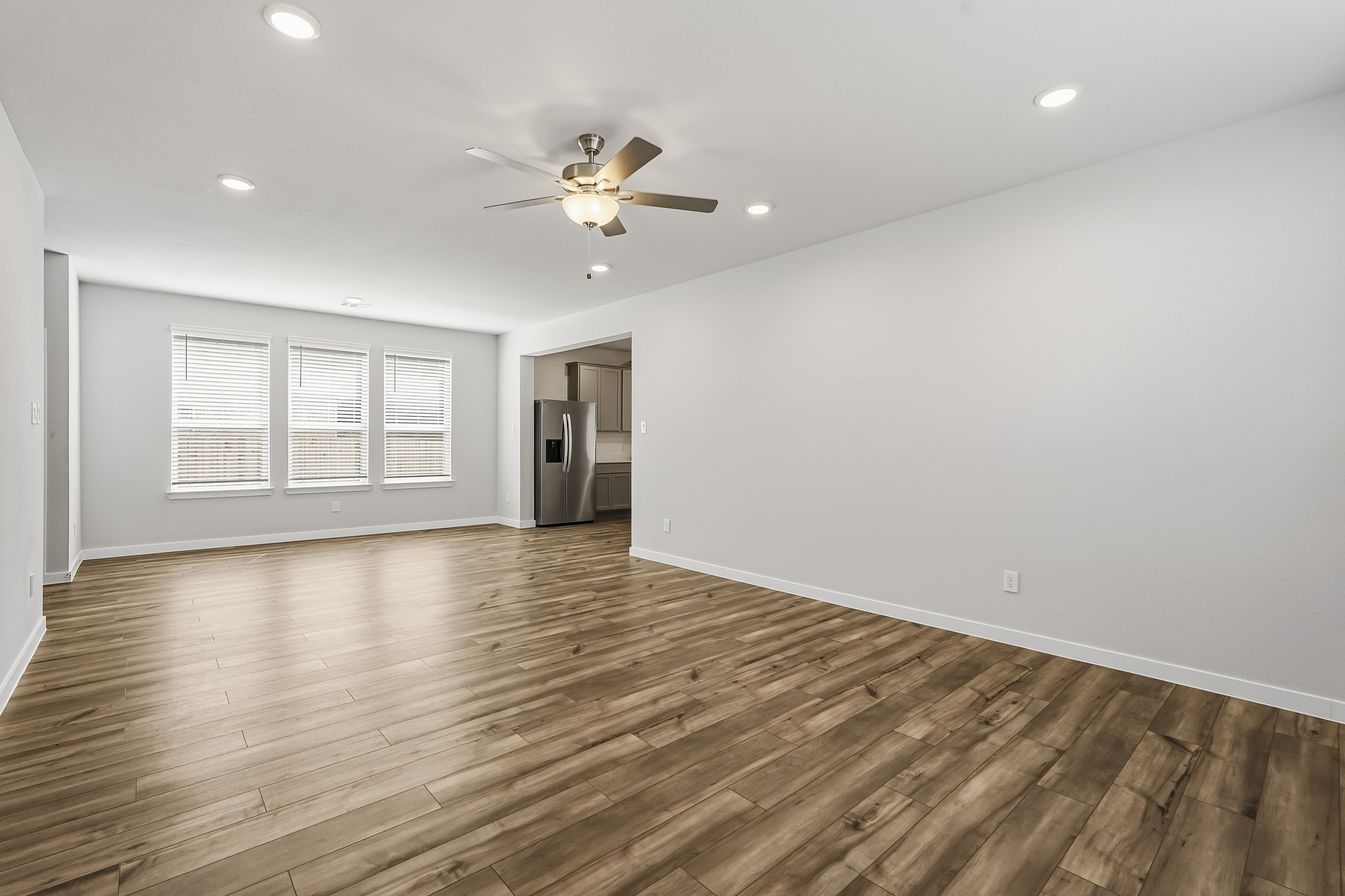 A room with a wood floor and a ceiling fan.