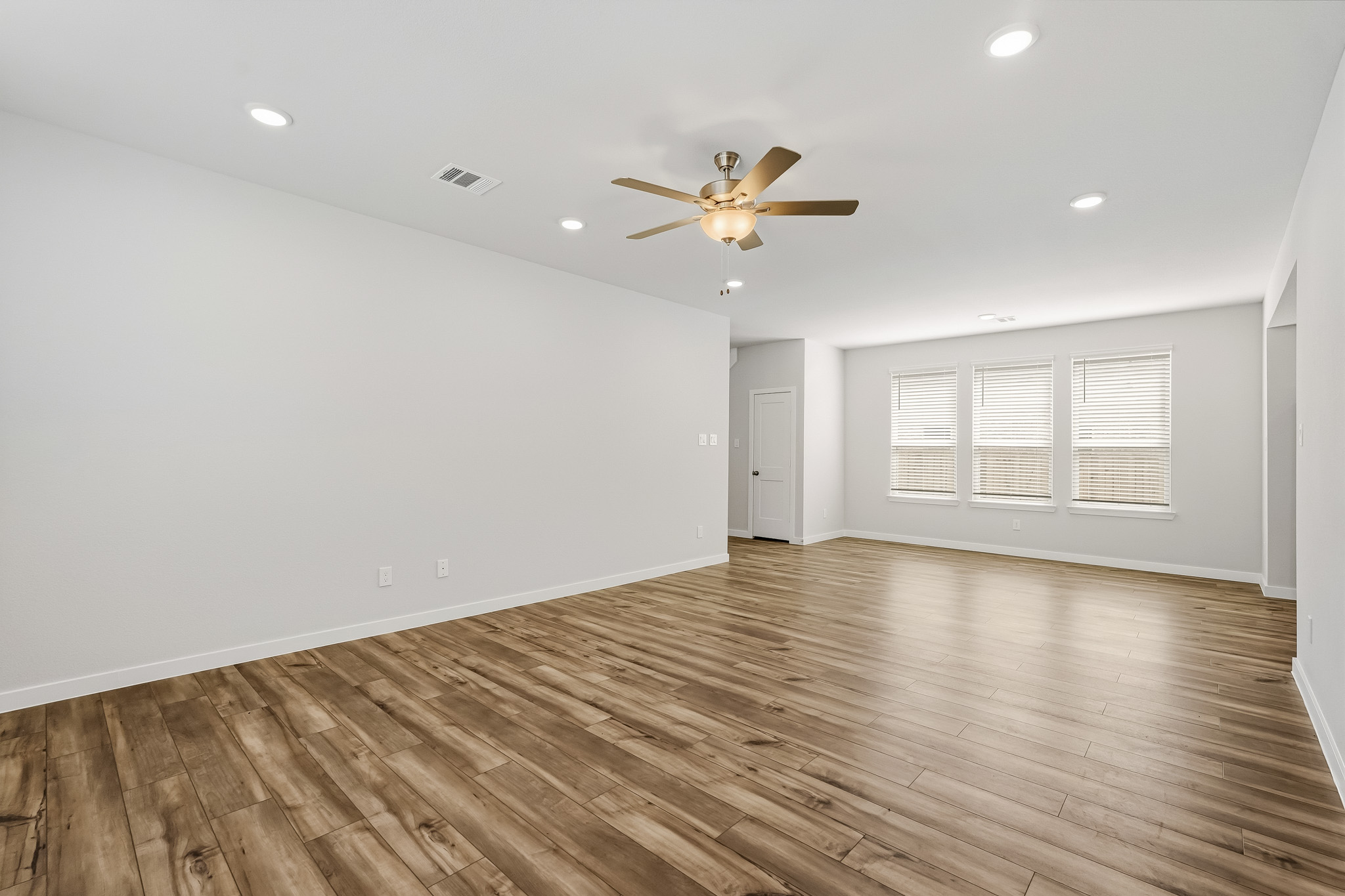 A room with a wood floor and a ceiling fan.