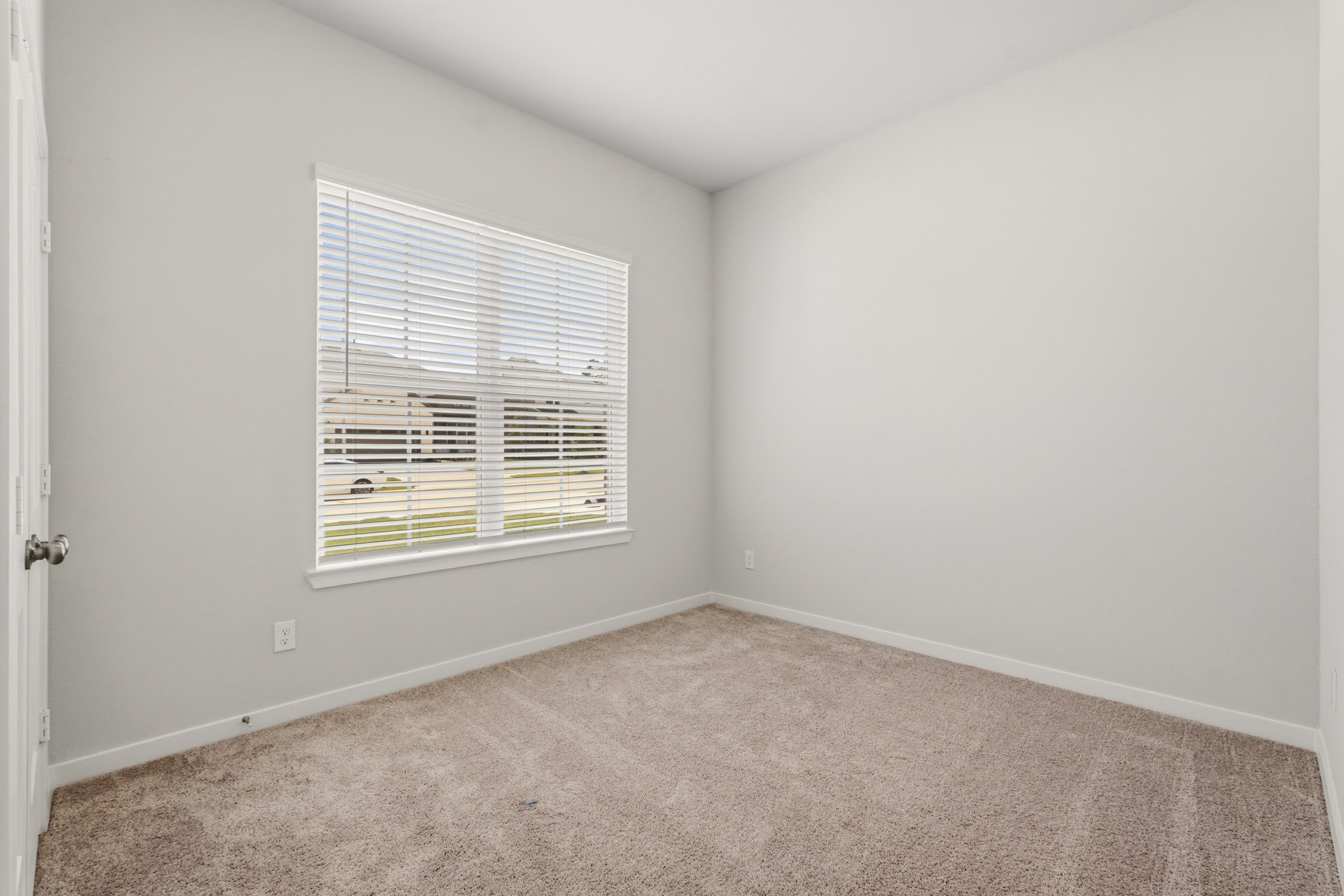 A room with a window and carpet.