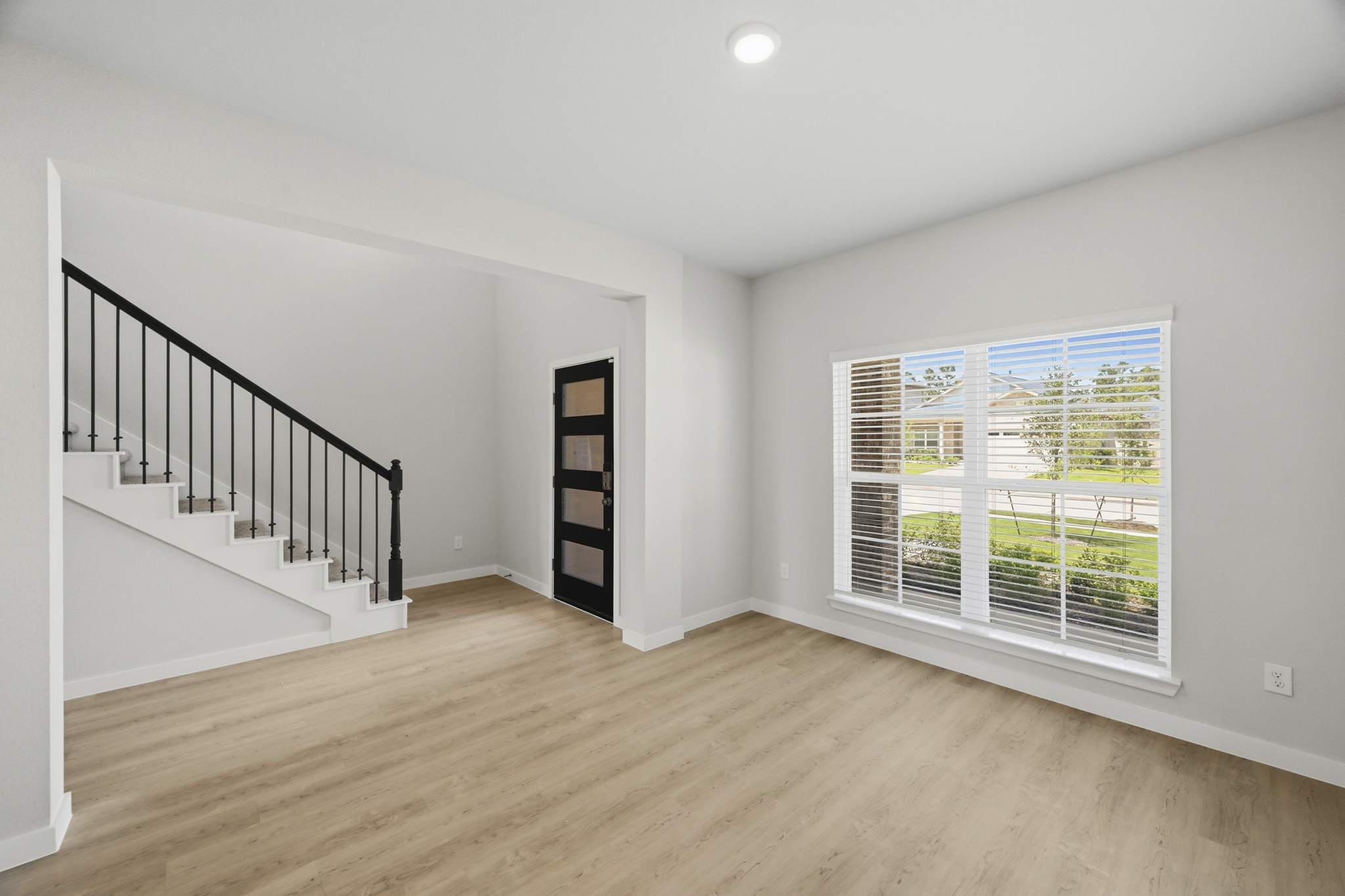 A room with a wood floor and a staircase.