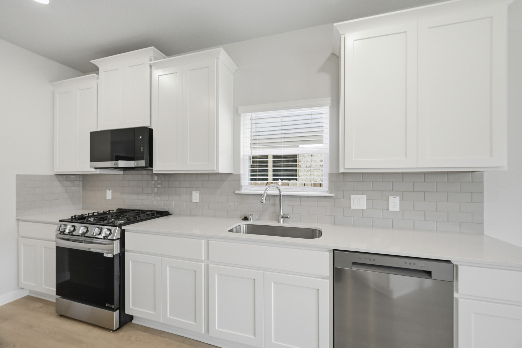 A kitchen with white cabinets.