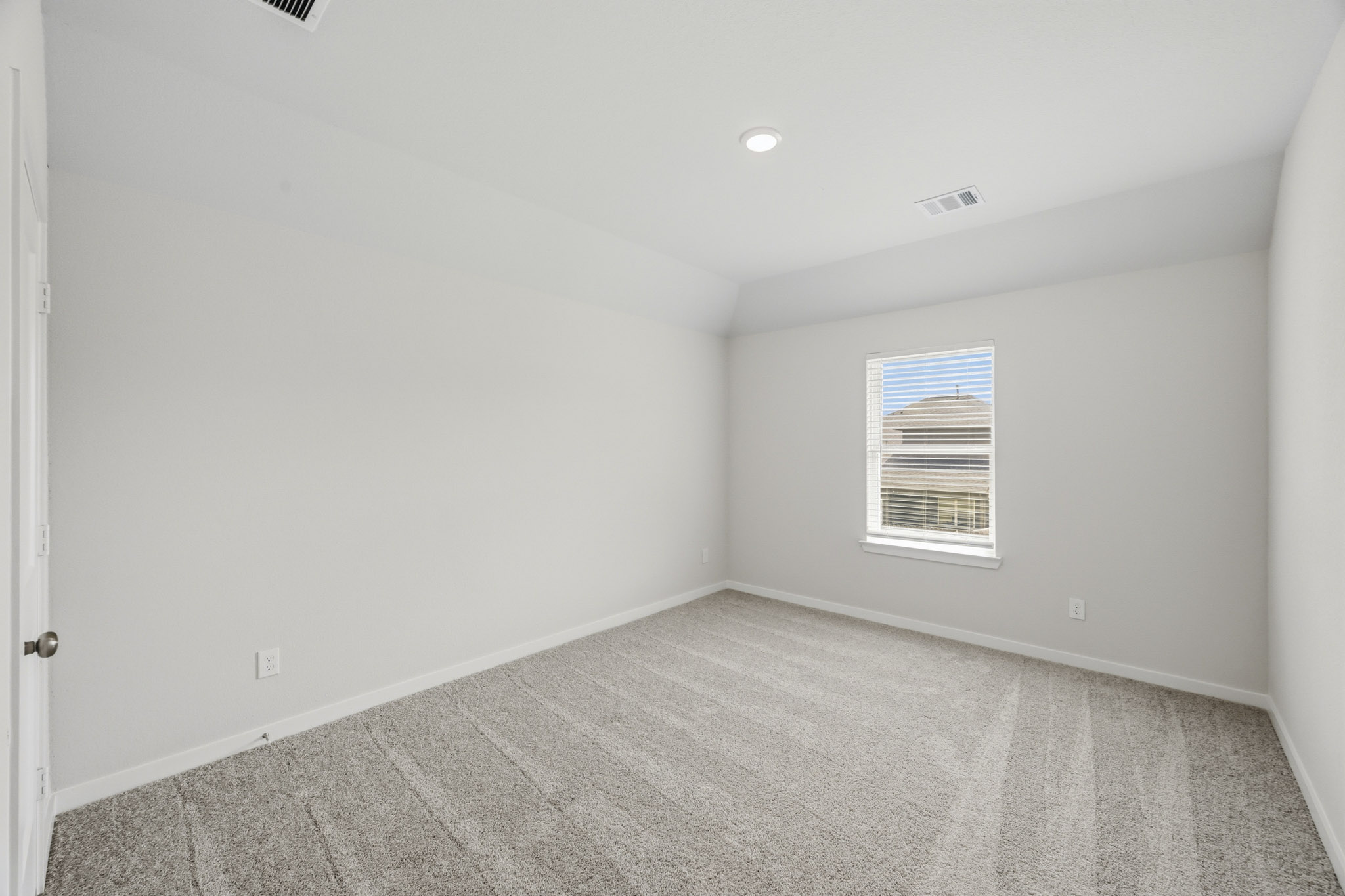 A room with a carpet and a window.