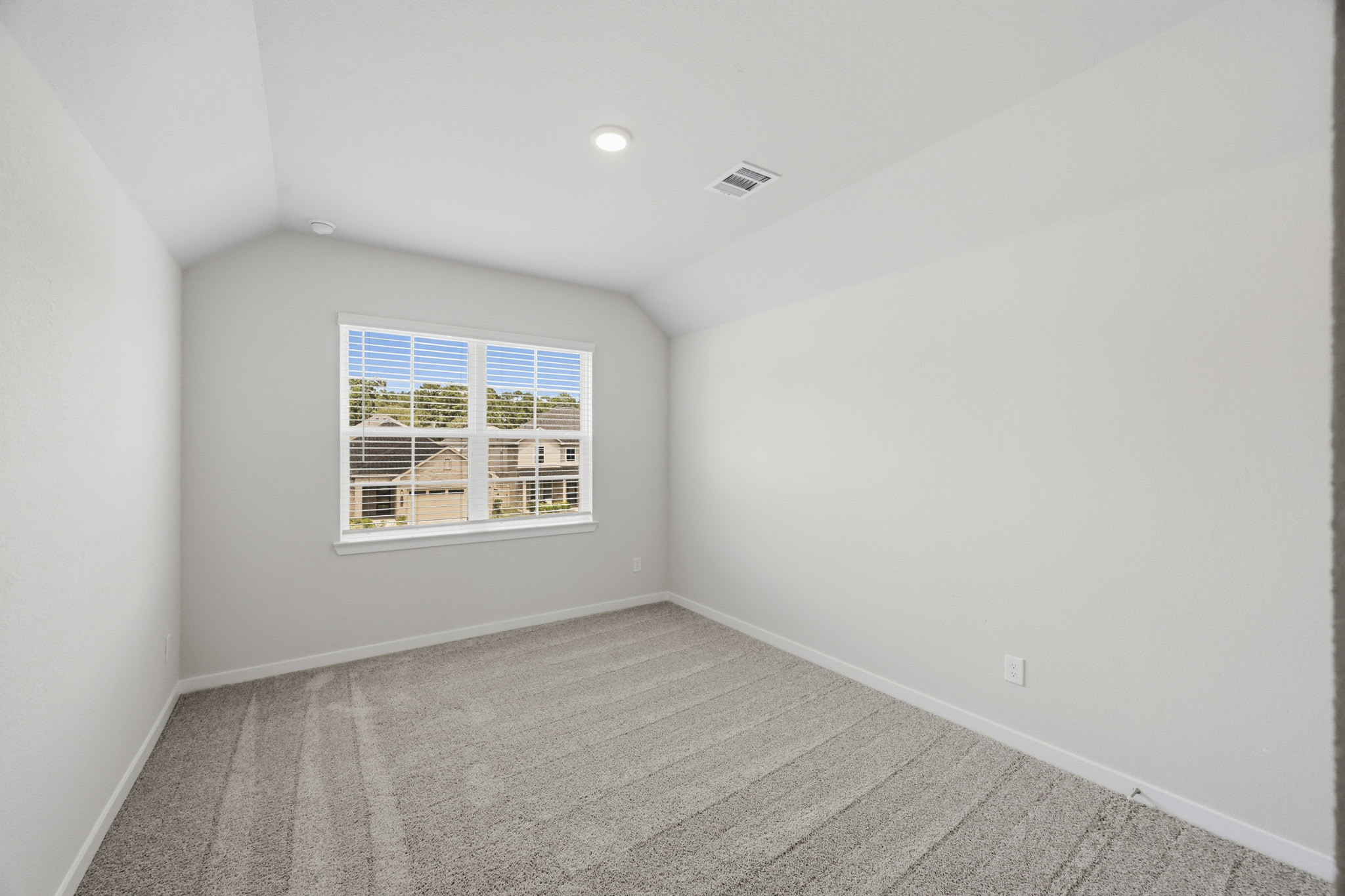 A room with a window and a white wall.