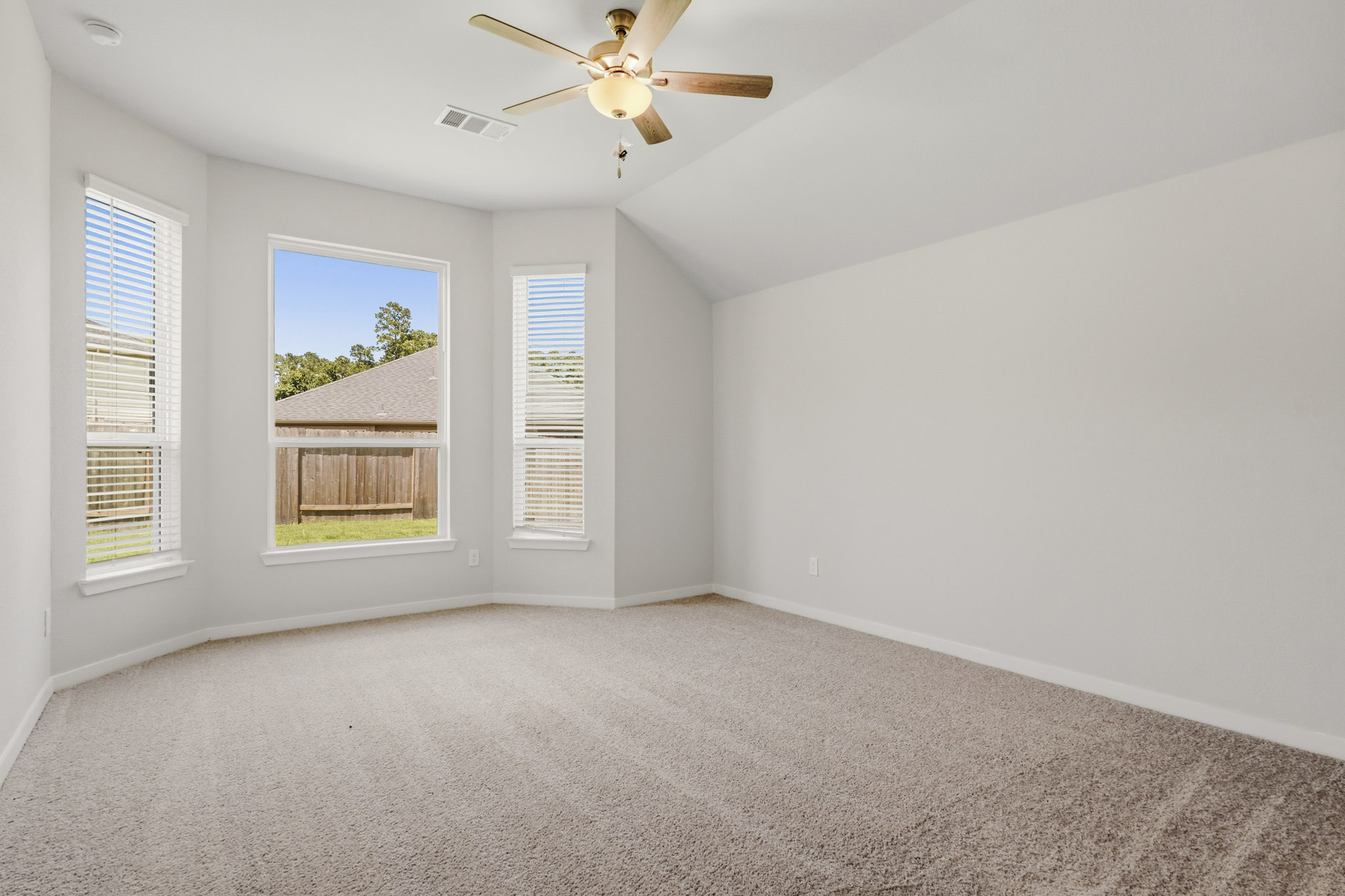 A room with a ceiling fan and a window.