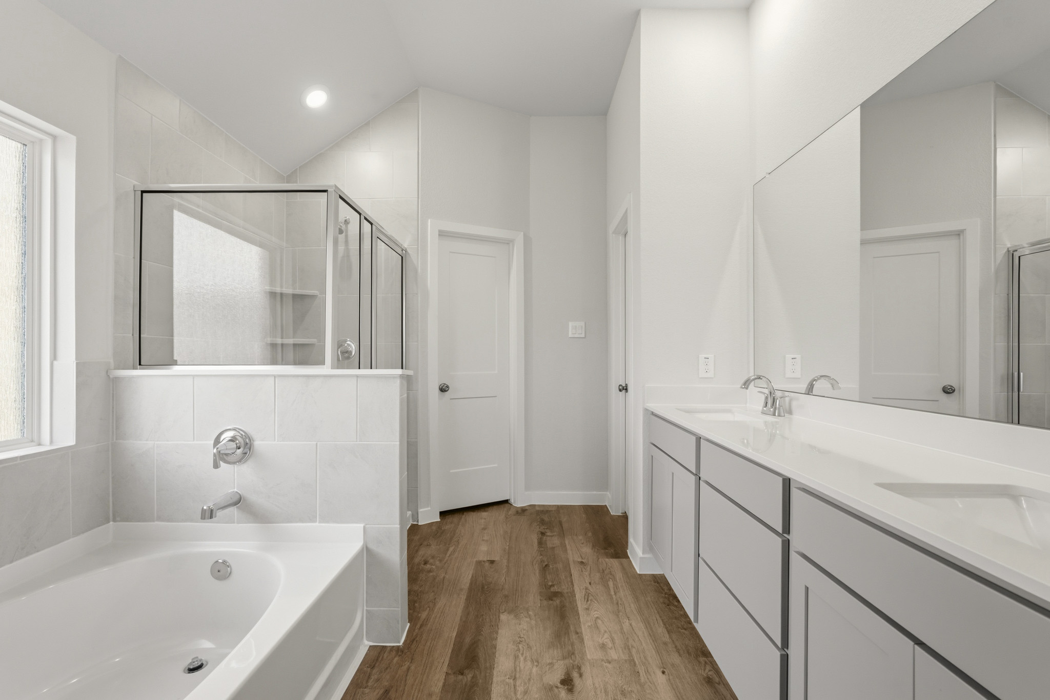 A bathroom with a tub sink and mirror.