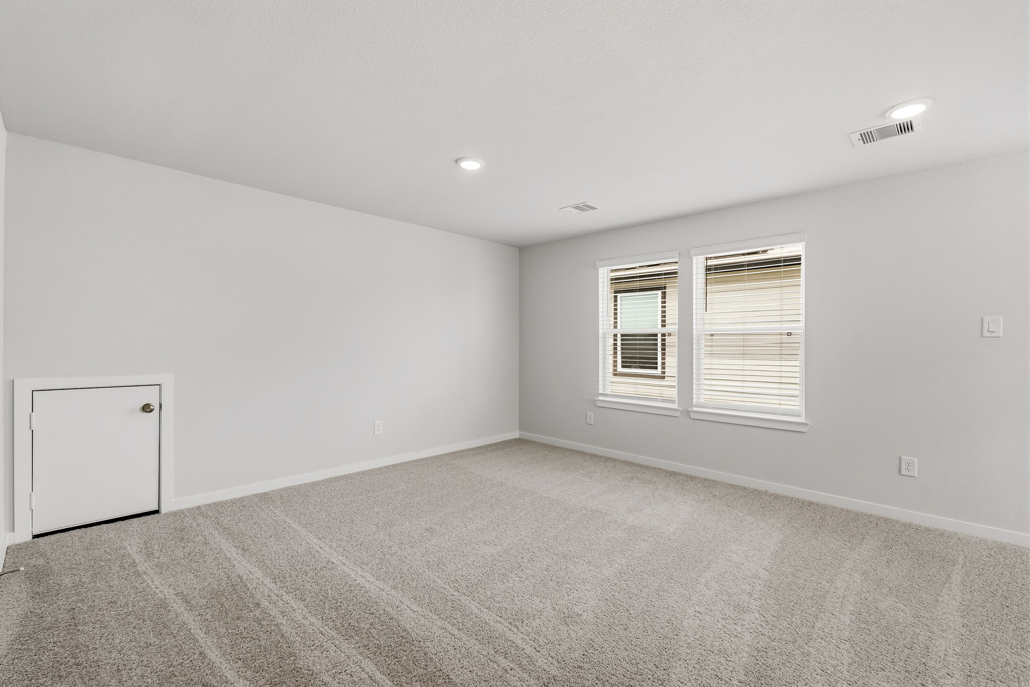 A room with a white wall and a window.