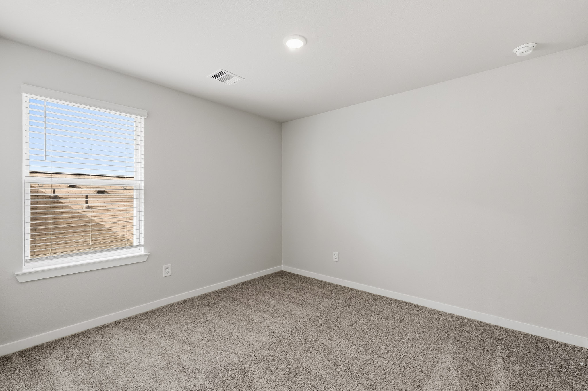 A room with a window and a carpet.