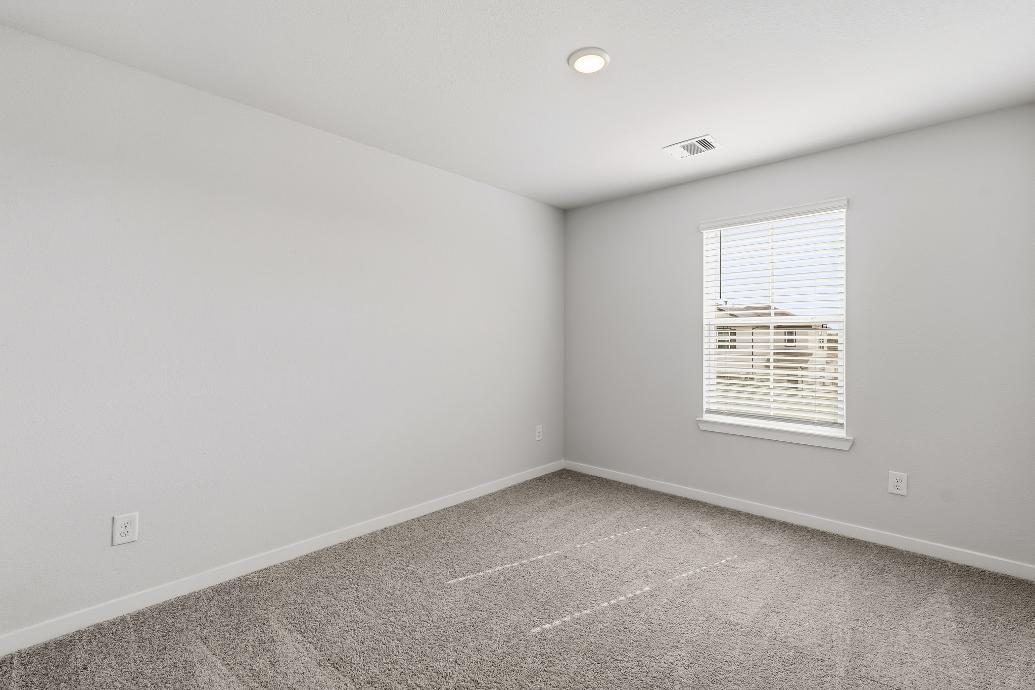 A room with a window and a vent.