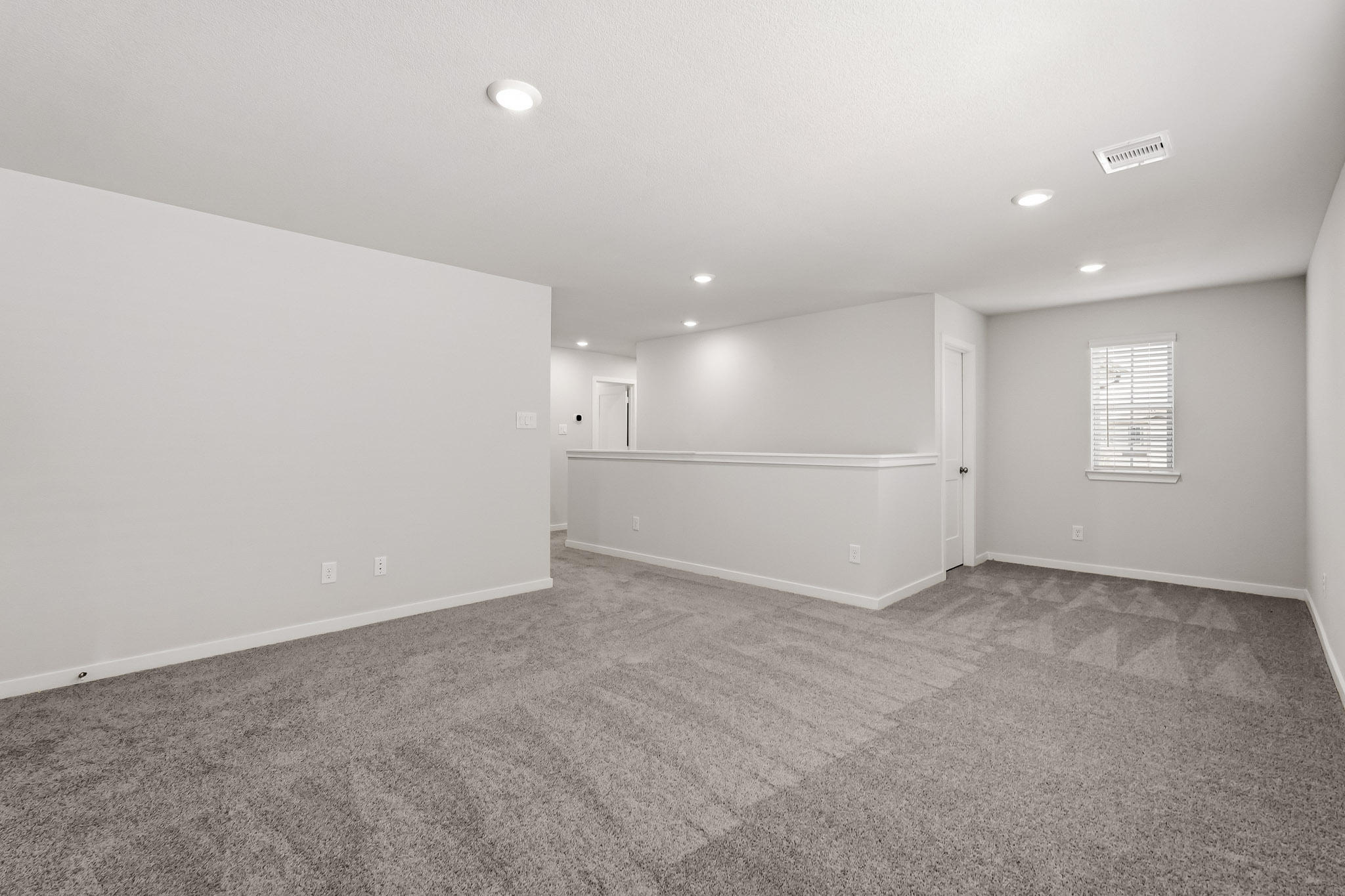 A room with a carpet and a door.