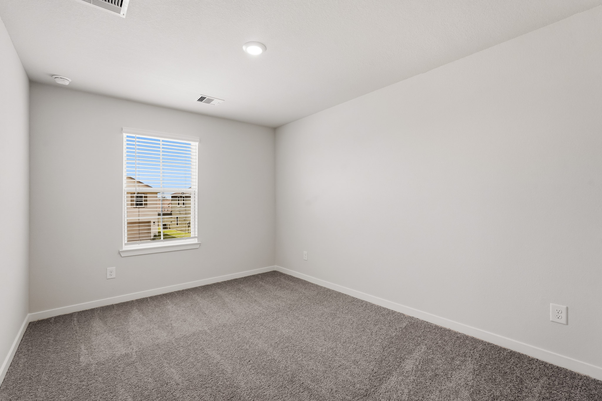 A room with a window and a carpet.
